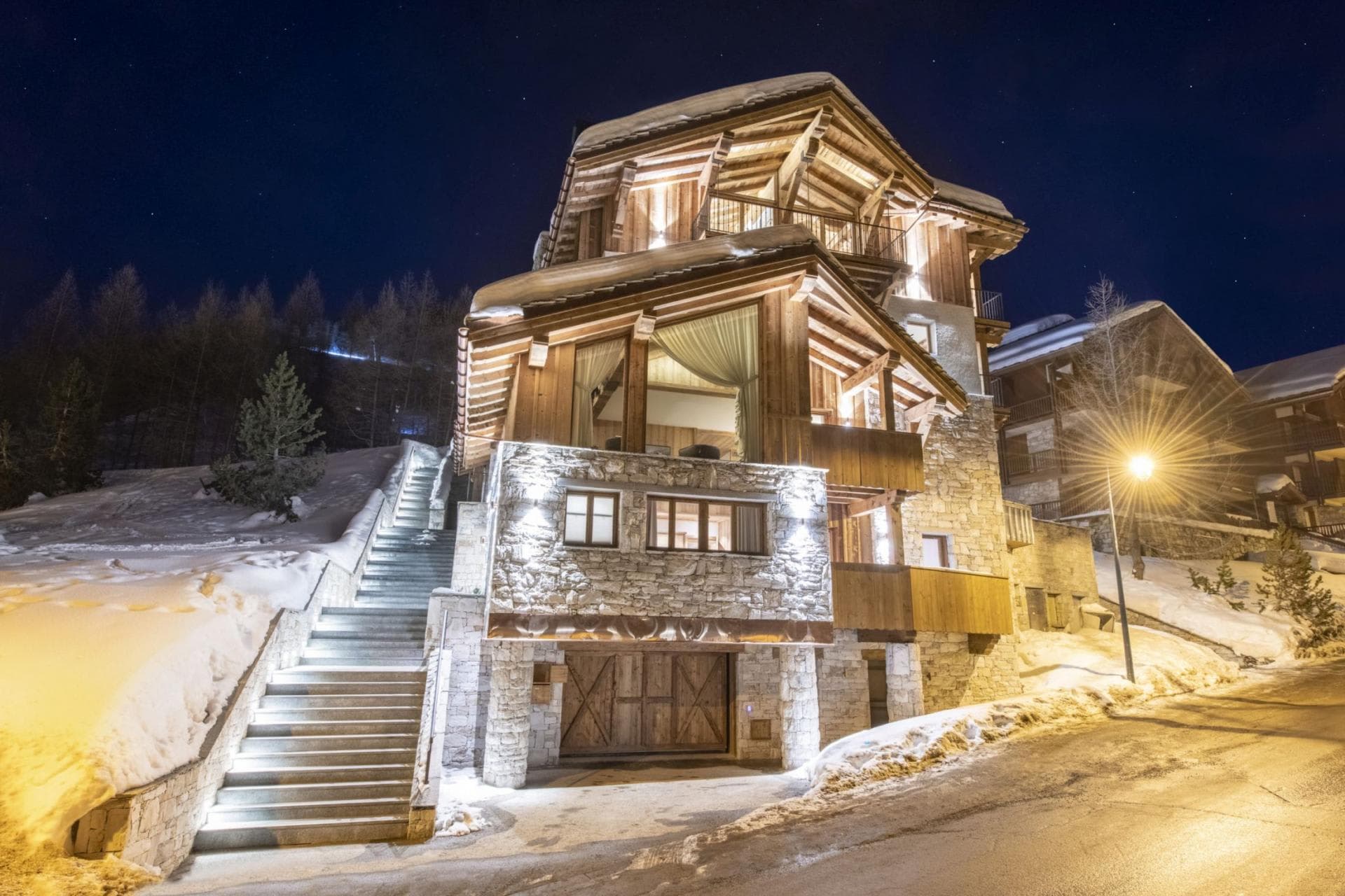 Ski-in chalet exterior featuring stone masonry and heated outdoor stairs