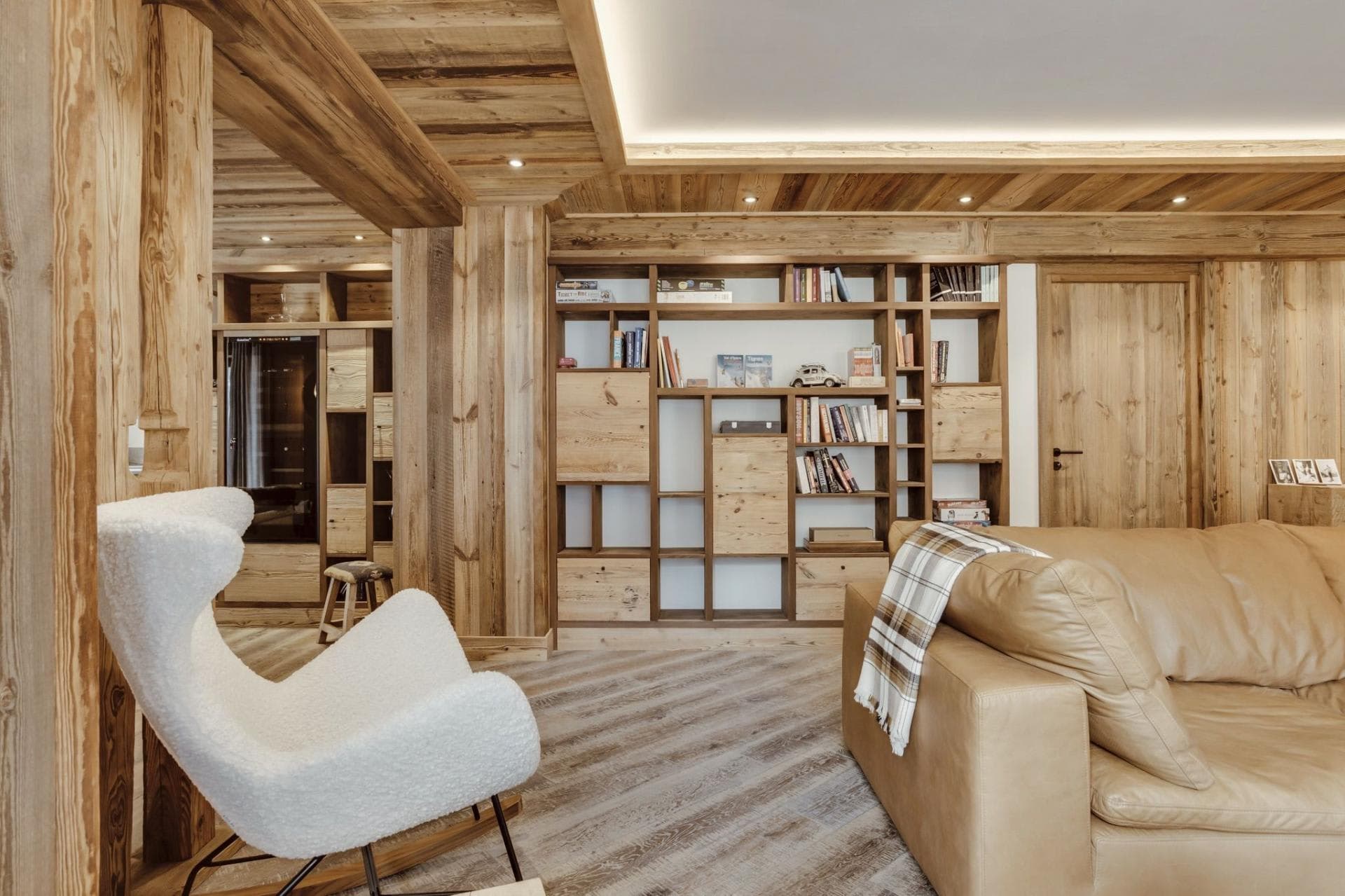 Living area with reclaimed wood paneling and custom library shelving