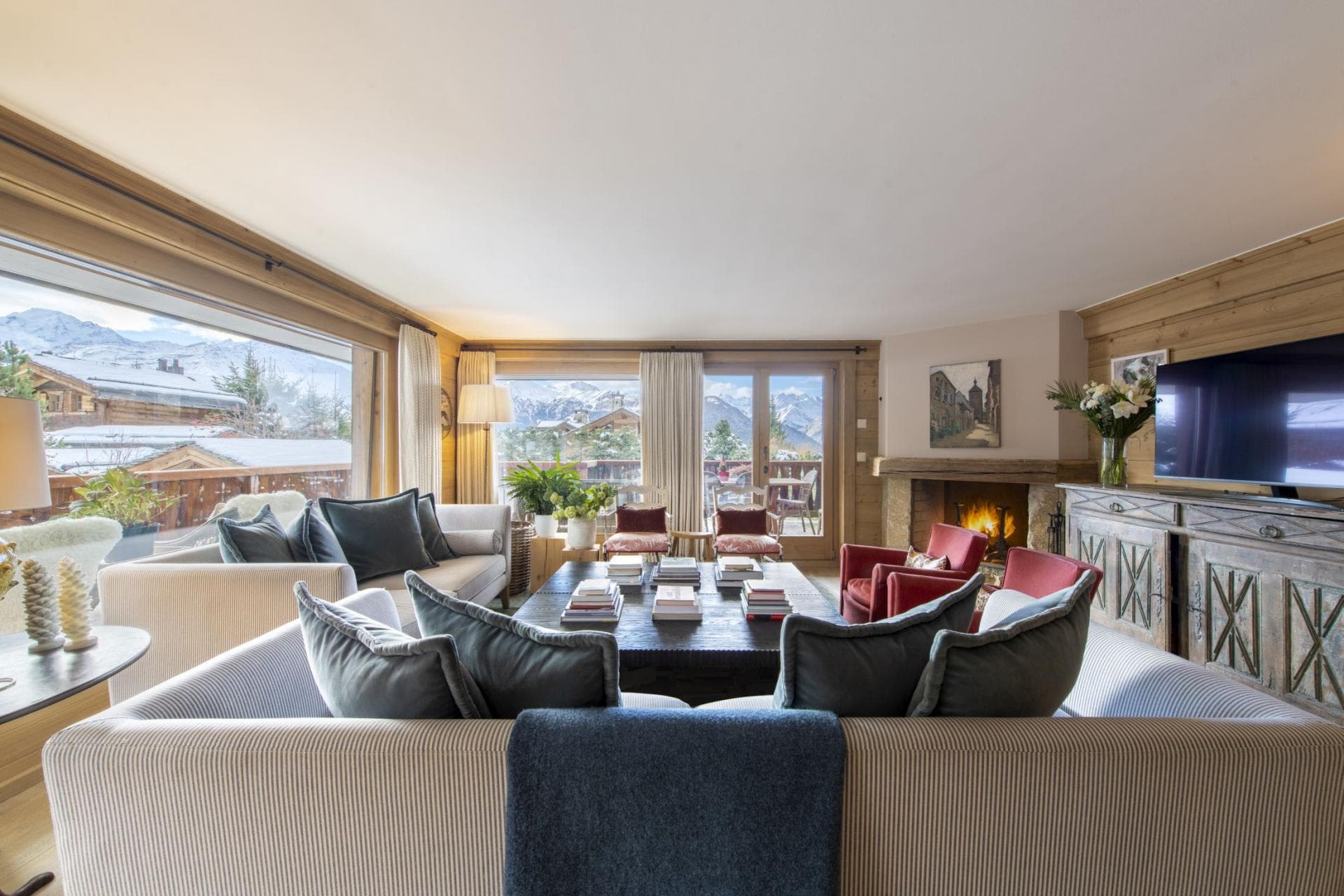 Living area with wood-burning fireplace and mountain-view balcony access