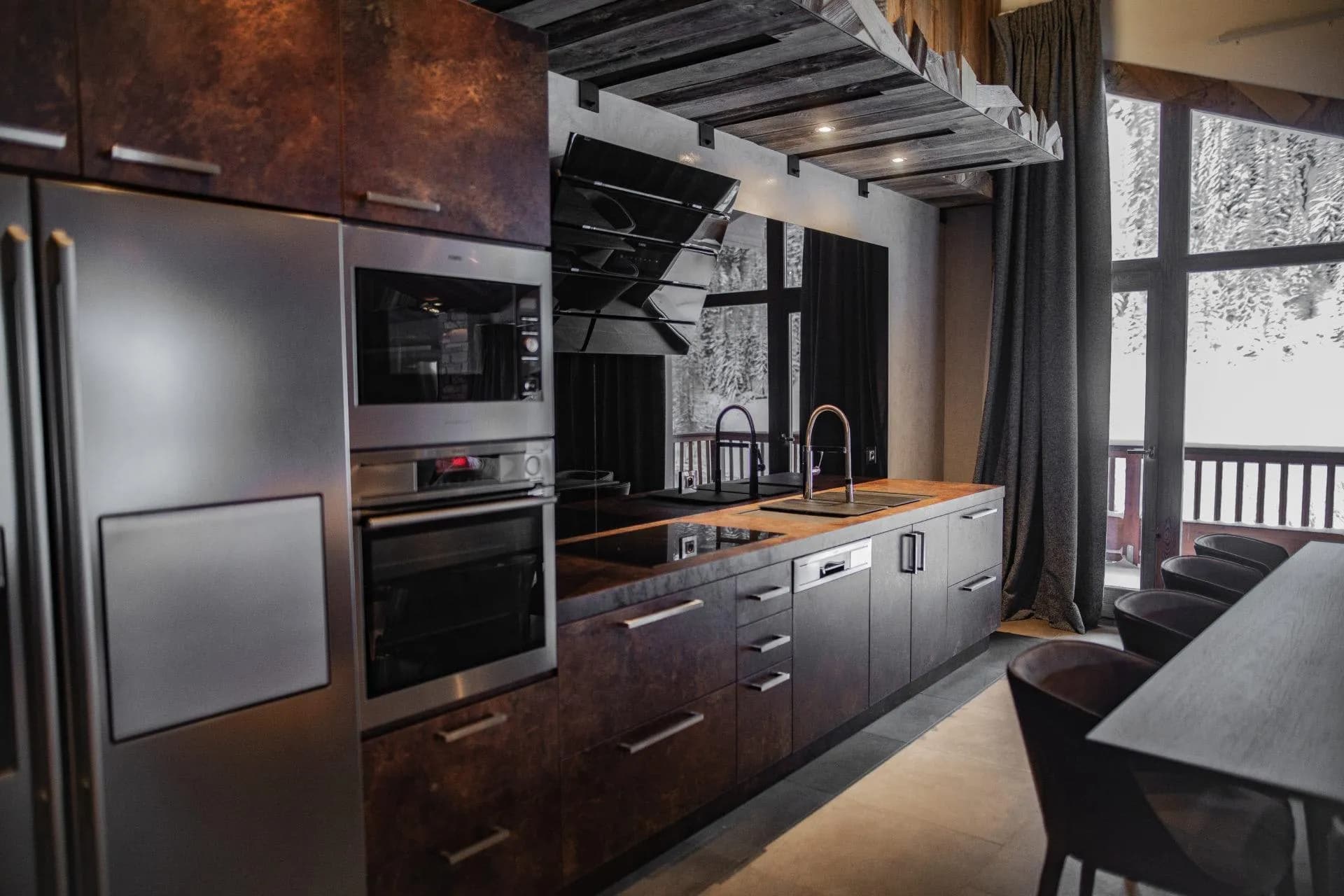 Kitchen with integrated wall oven and floor-to-ceiling forest views