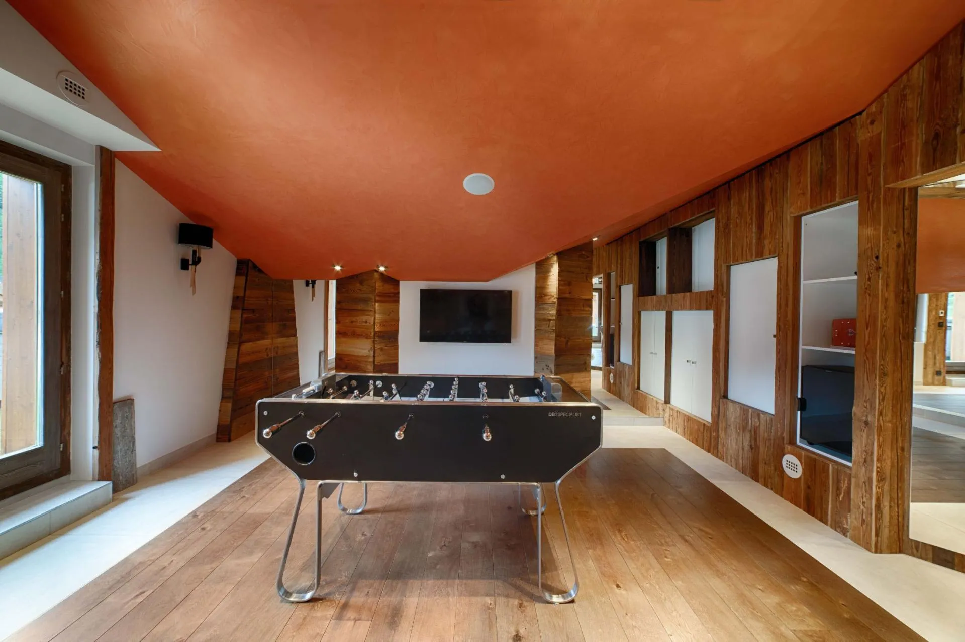 Game room with foosball table and wall-mounted TV