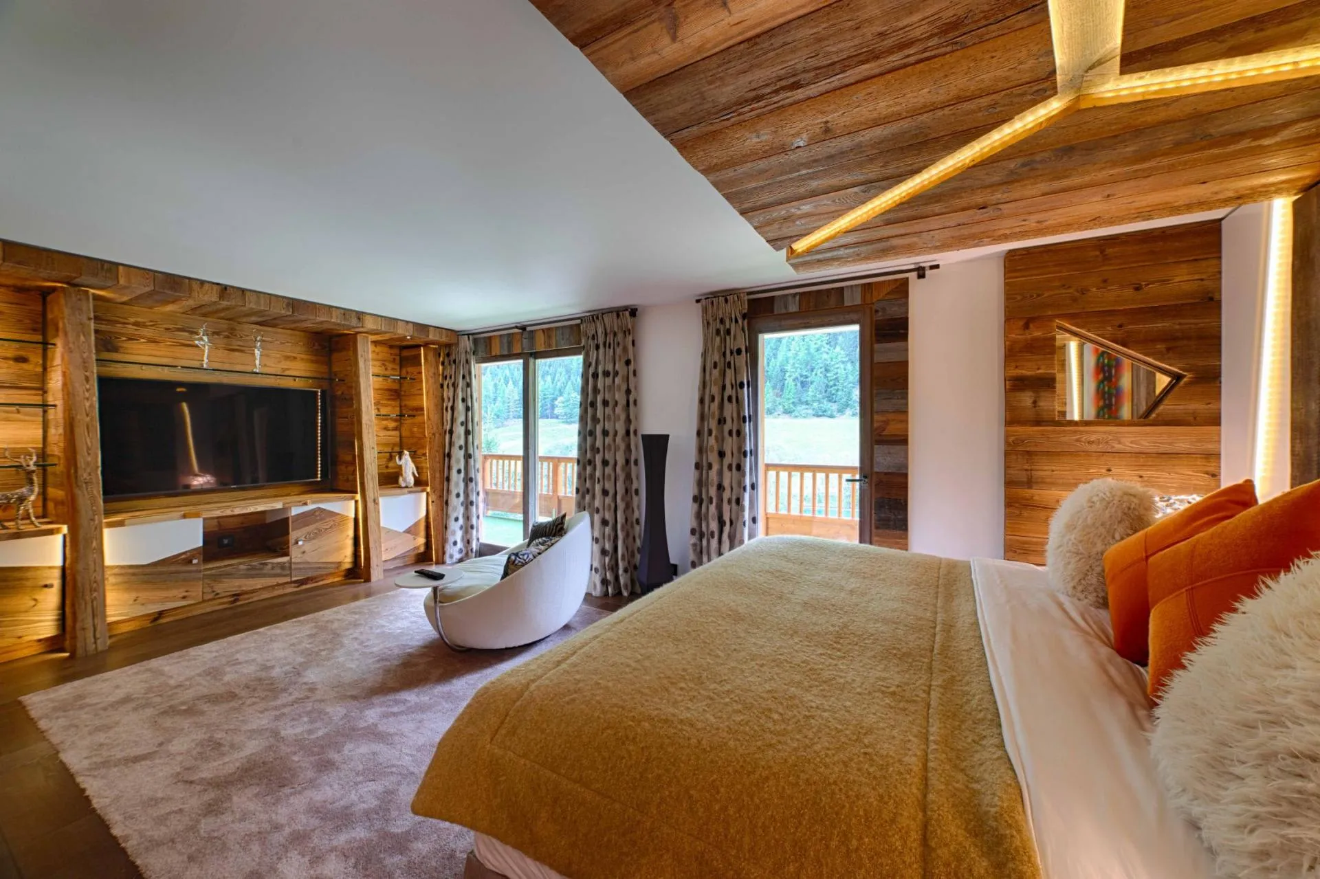 Primary bedroom with king bed and private balcony with forest views