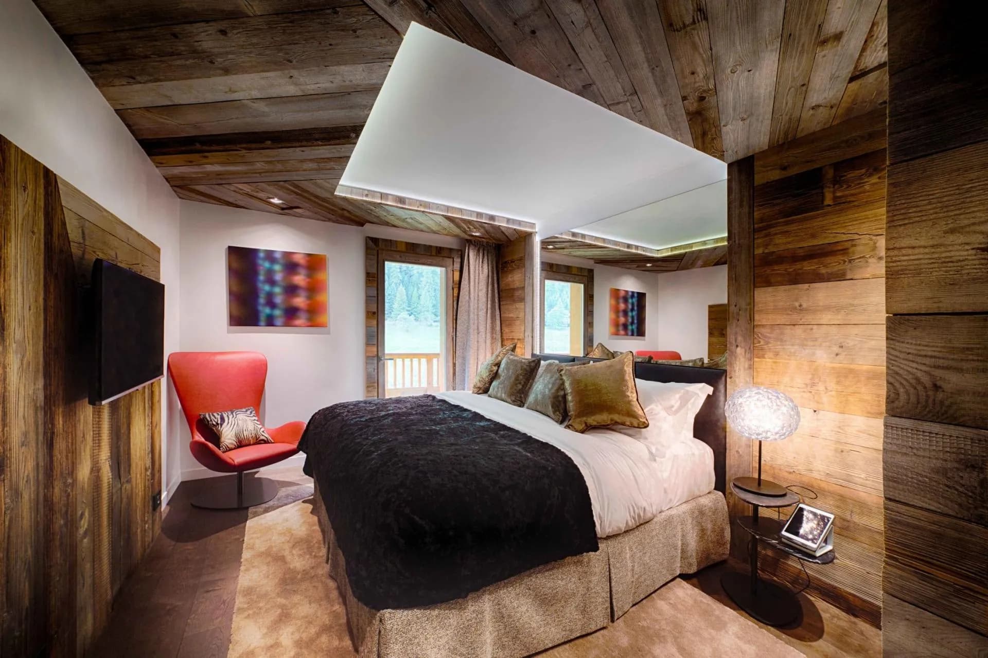 King bedroom with reclaimed wood paneling and private balcony access
