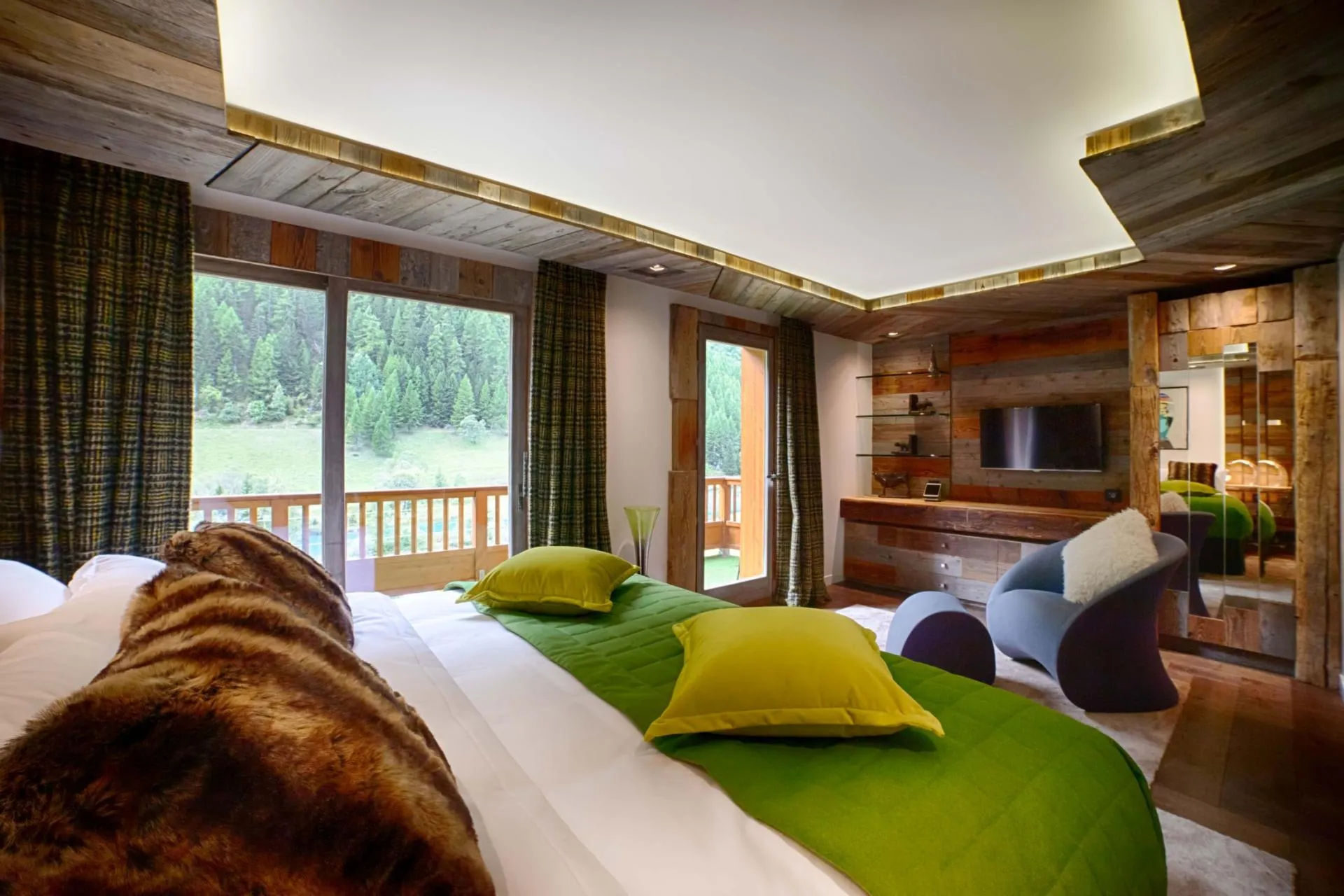 Bedroom with king bed, private balcony access, and forest views