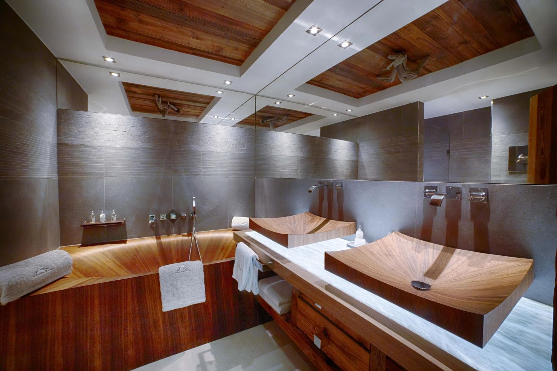 Bathroom with dual wooden vessel sinks and matching wood soaking tub