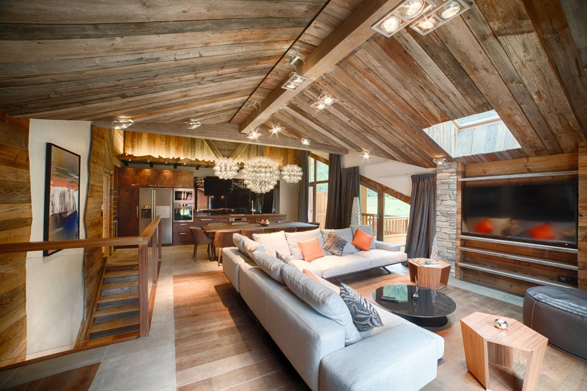 Open-plan living area with vaulted wood ceilings and outdoor balcony access