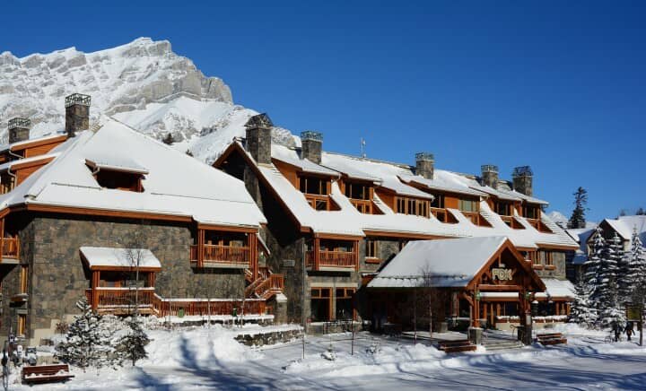 Stone and timber exterior with private balconies and mountain backdrop