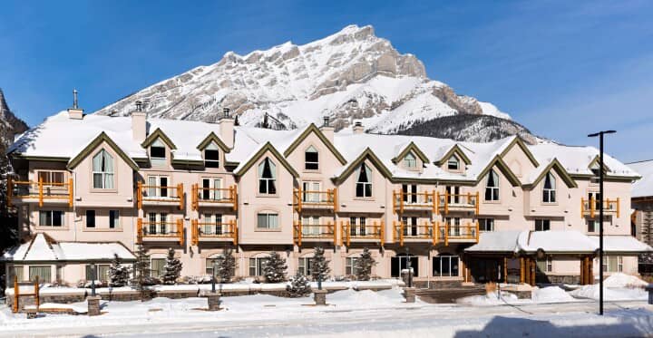 Ski-in/ski-out lodge exterior with private balconies and mountain backdrop
