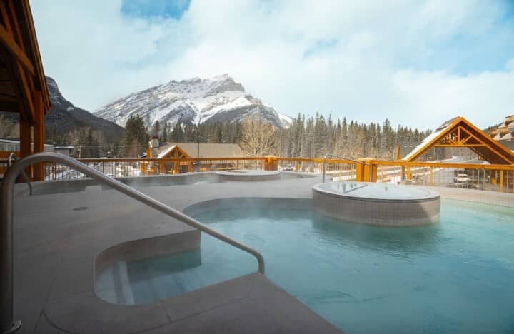Shared outdoor hot tubs with mountain views and handrail access