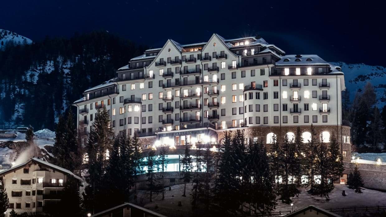 Exterior night view; private balconies and mountain backdrop