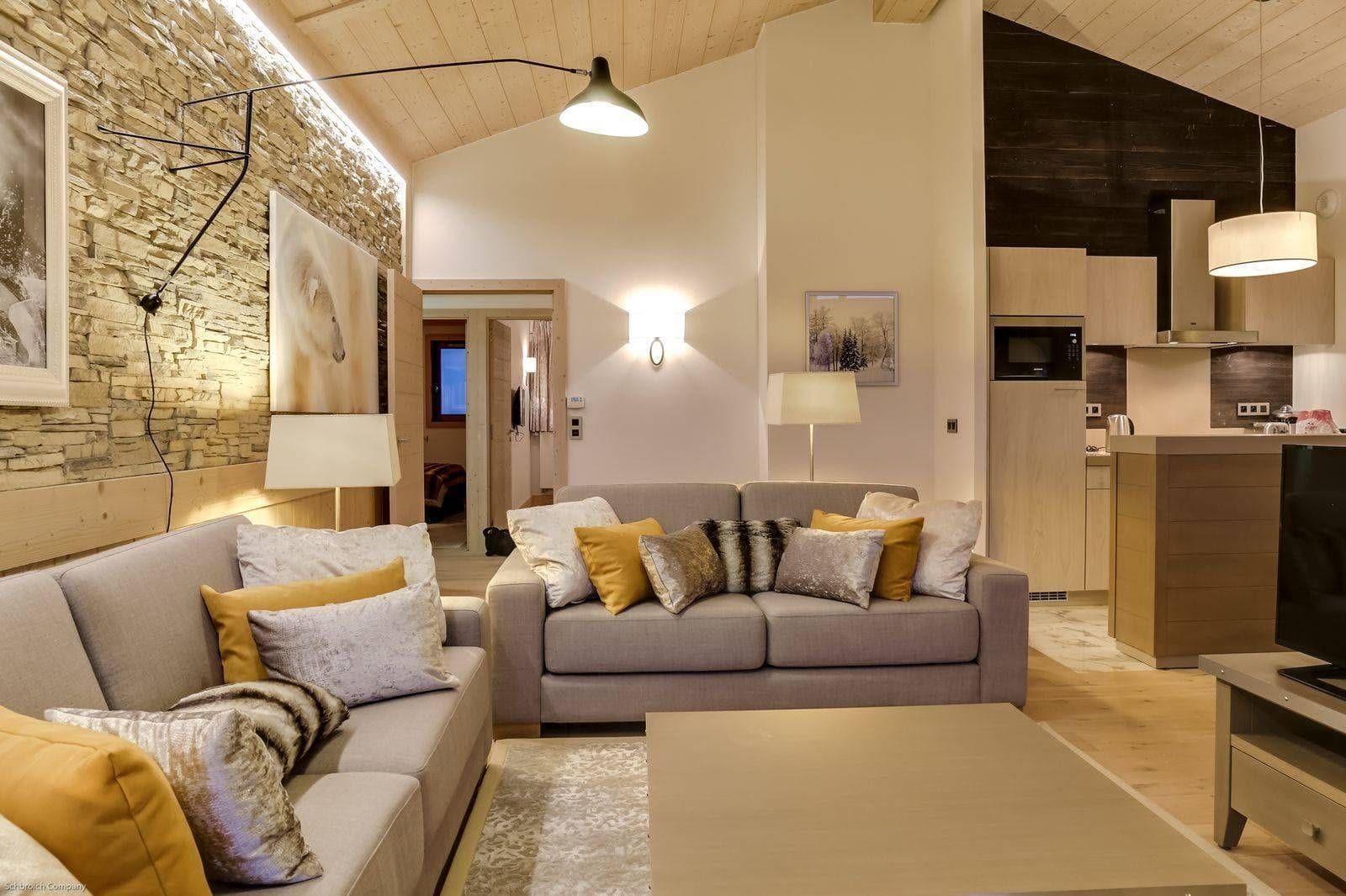 Open-plan living area and kitchenette with vaulted wood ceilings