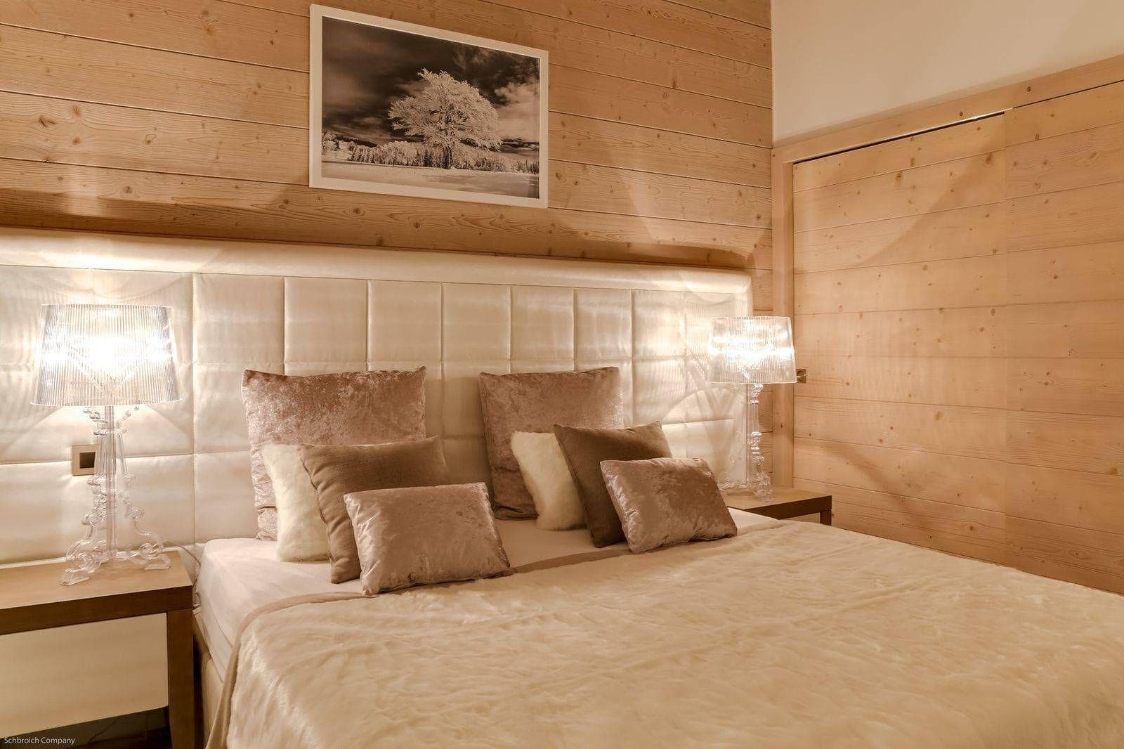 Guest bedroom with king bed and wood paneled walls