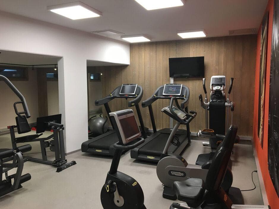 Fitness center with Technogym cardio machines and wall-mounted TV