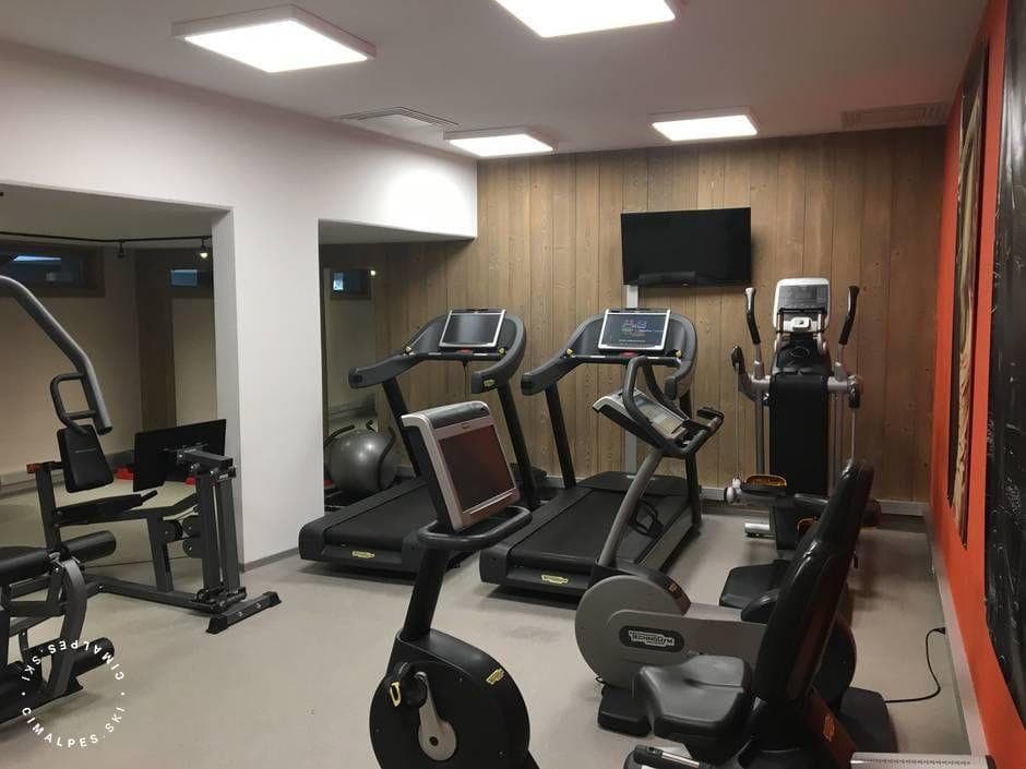 Fitness room with Technogym treadmills, stationary bikes, and wall-mounted TV