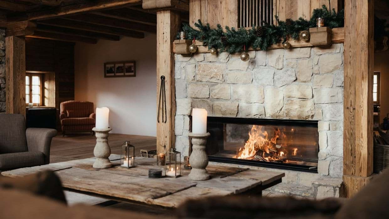 Stone-clad wood-burning fireplace and living area with reclaimed wood beams