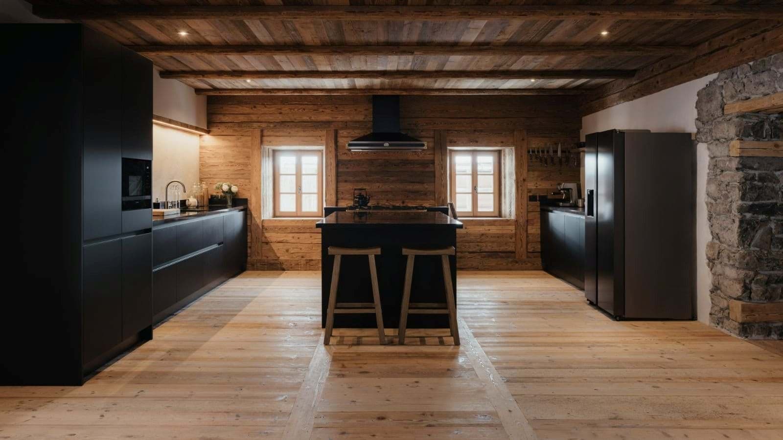 Kitchen with matte black cabinetry, central island, and original timber walls