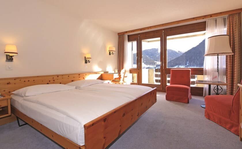 Guest bedroom with king bed, desk, and mountain views