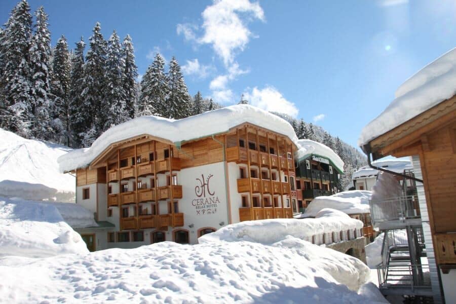 Hotel exterior with private balconies and direct access to snowy pine forests