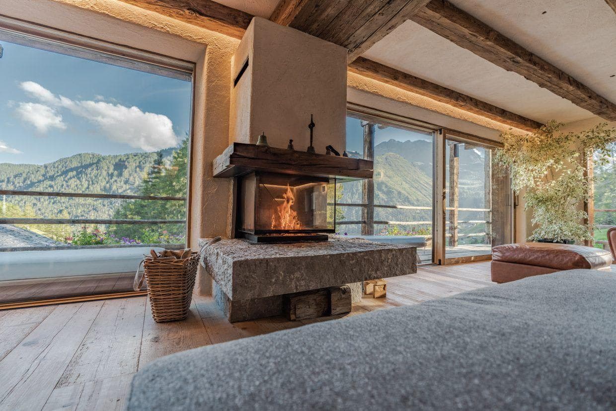 Wood-burning fireplace with floor-to-ceiling mountain views