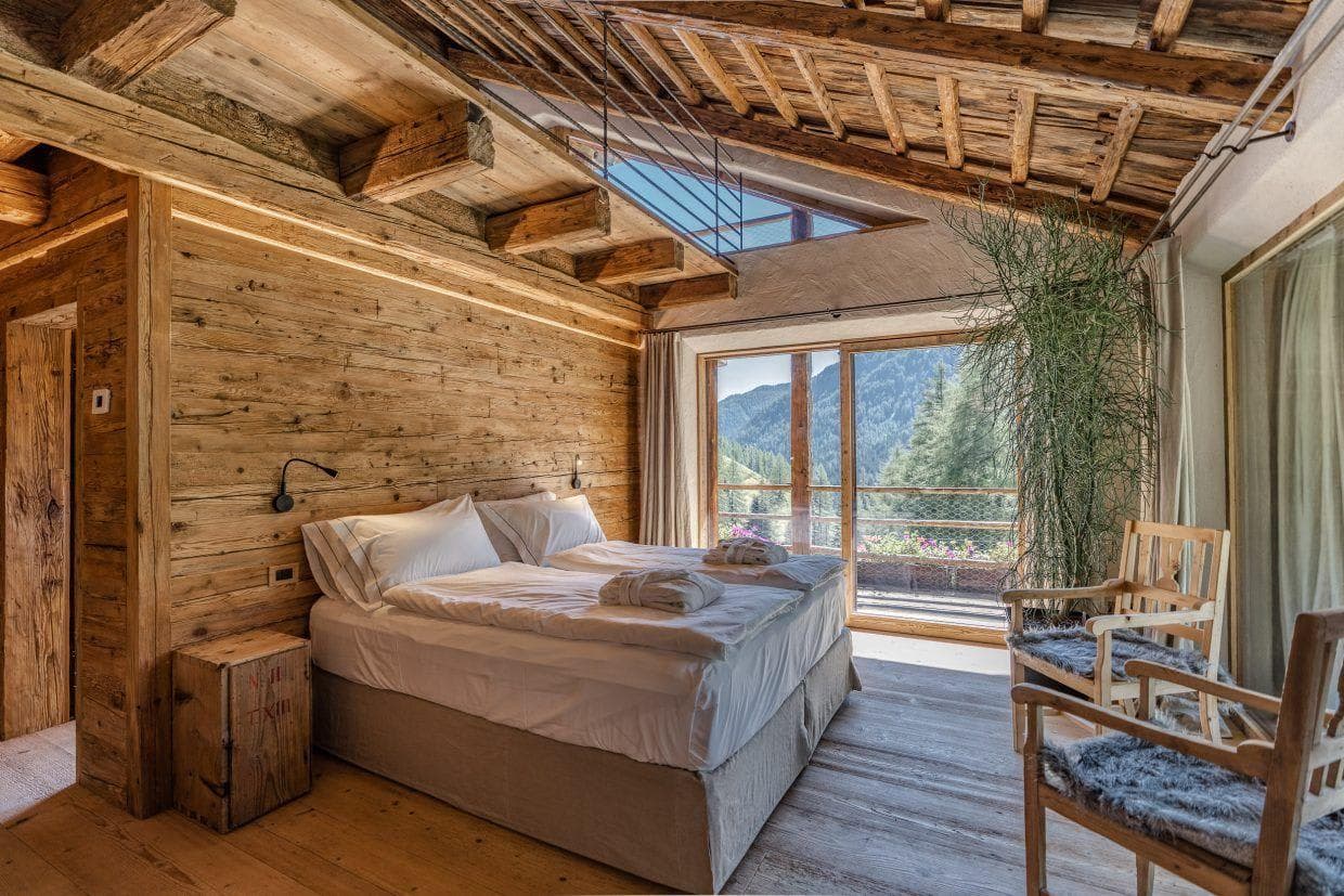 Loft bedroom with twin beds and sliding door to mountain-view balcony