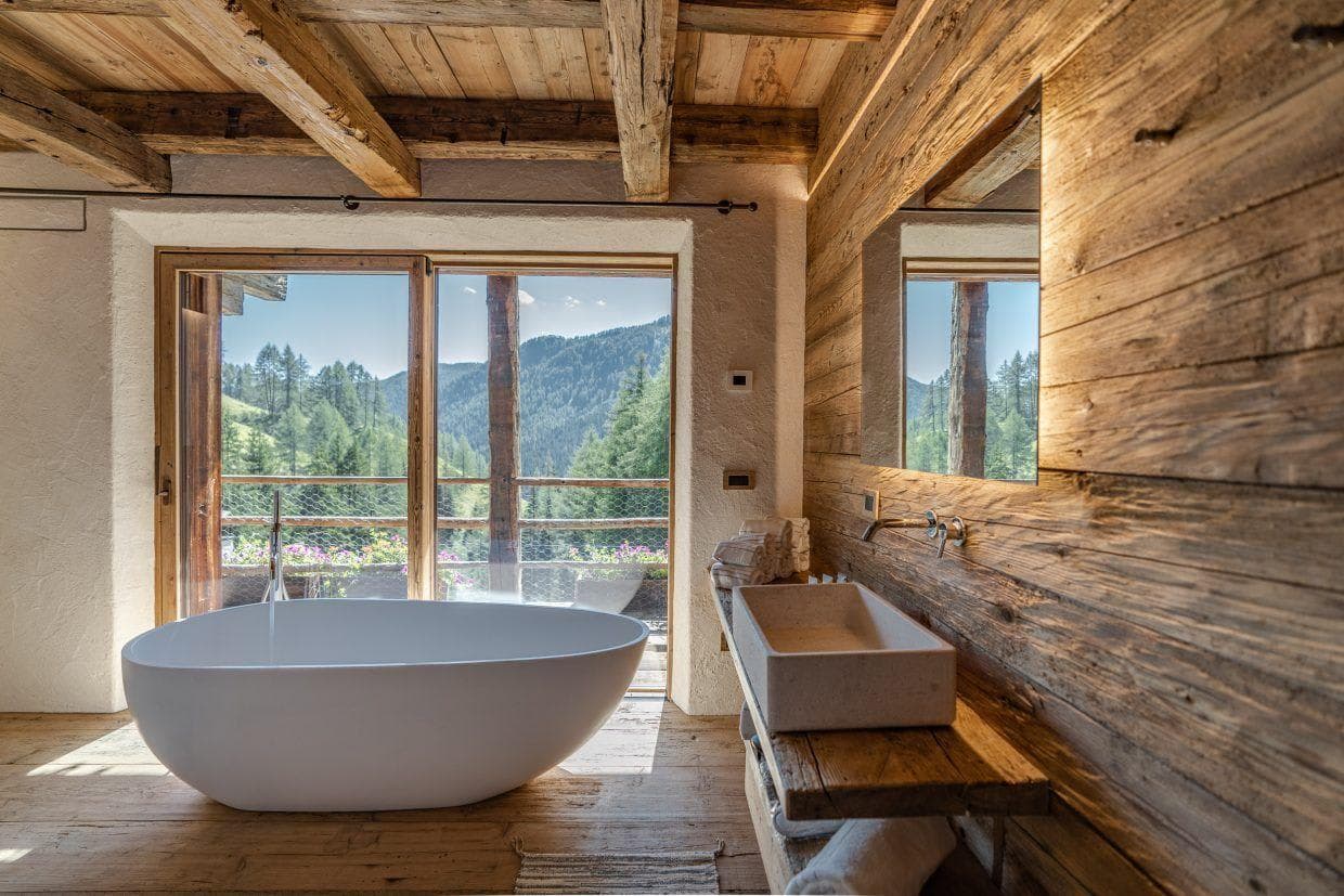 Bathroom with freestanding soaking tub and forest valley views