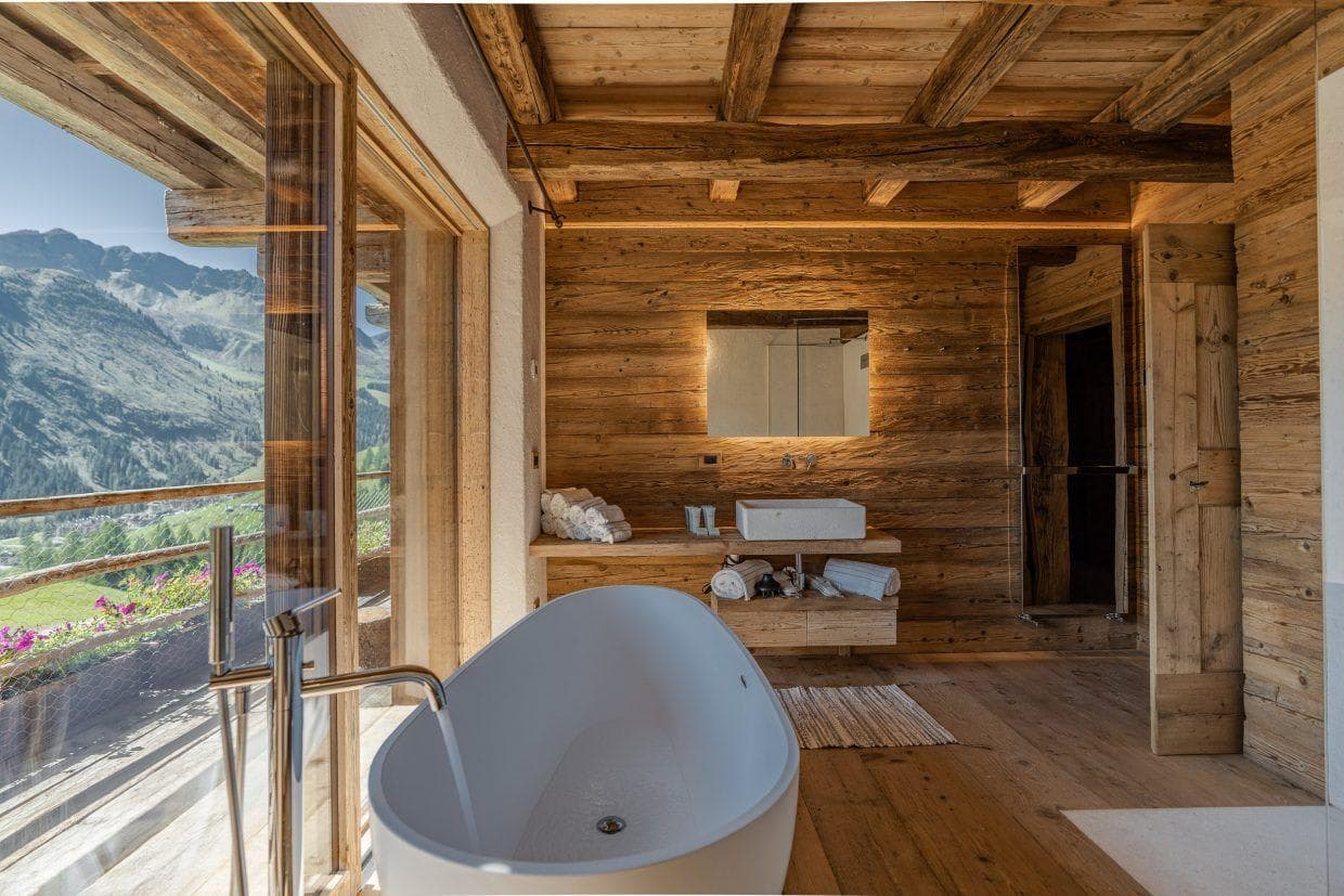 Bathroom with freestanding tub and balcony access; panoramic mountain views