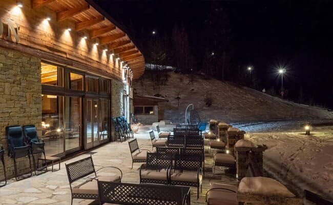 Stone patio with lounge seating and direct ski-in/ski-out slope access