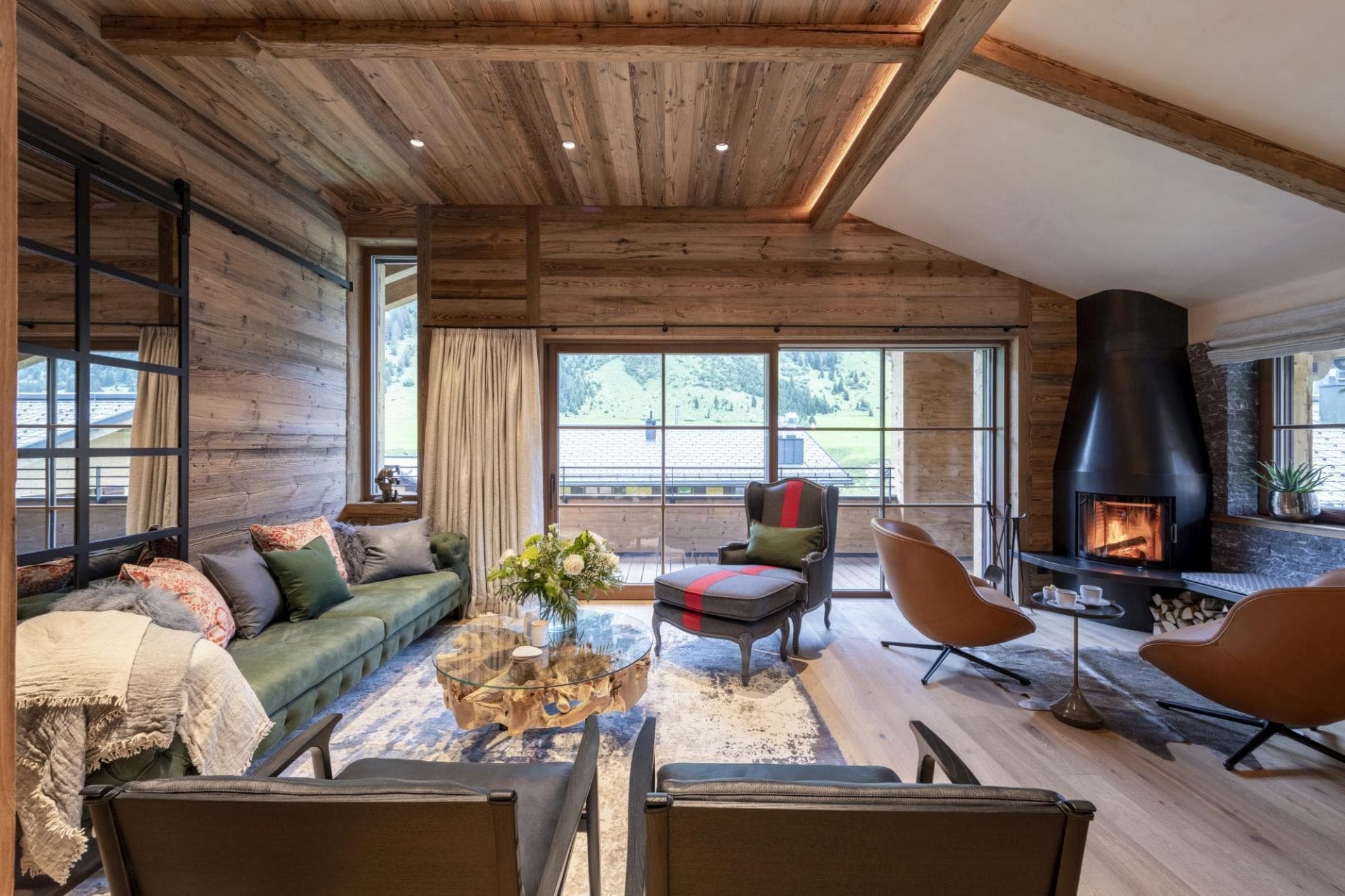 Living area with wood-burning fireplace and sliding doors to balcony