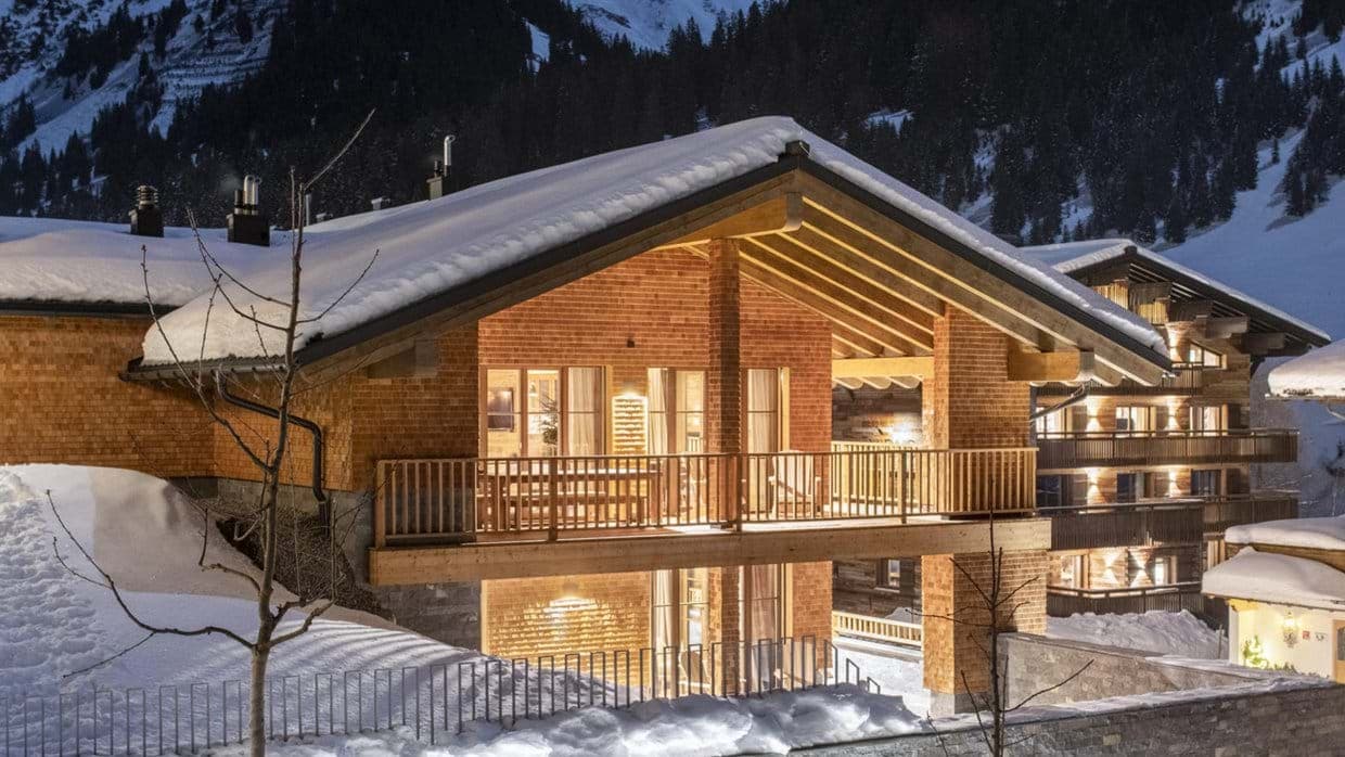 Chalet exterior featuring covered balcony with dining table and mountain views