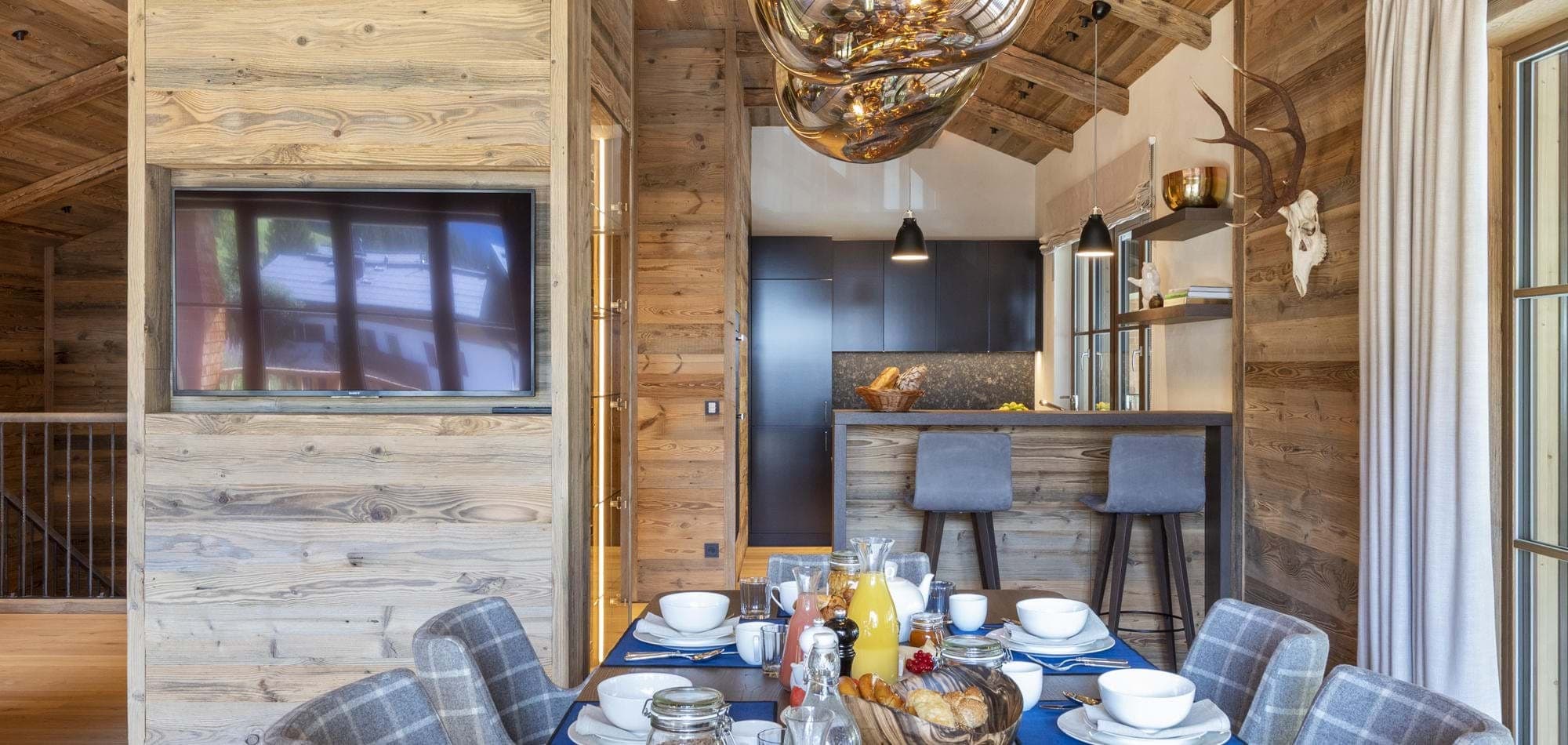 Open-plan dining area with smart TV and breakfast bar seating