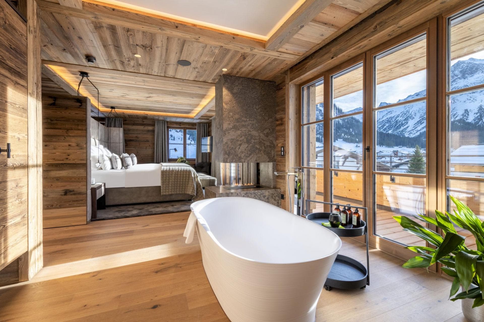 Primary bedroom with soaking tub and double-sided fireplace; mountain views