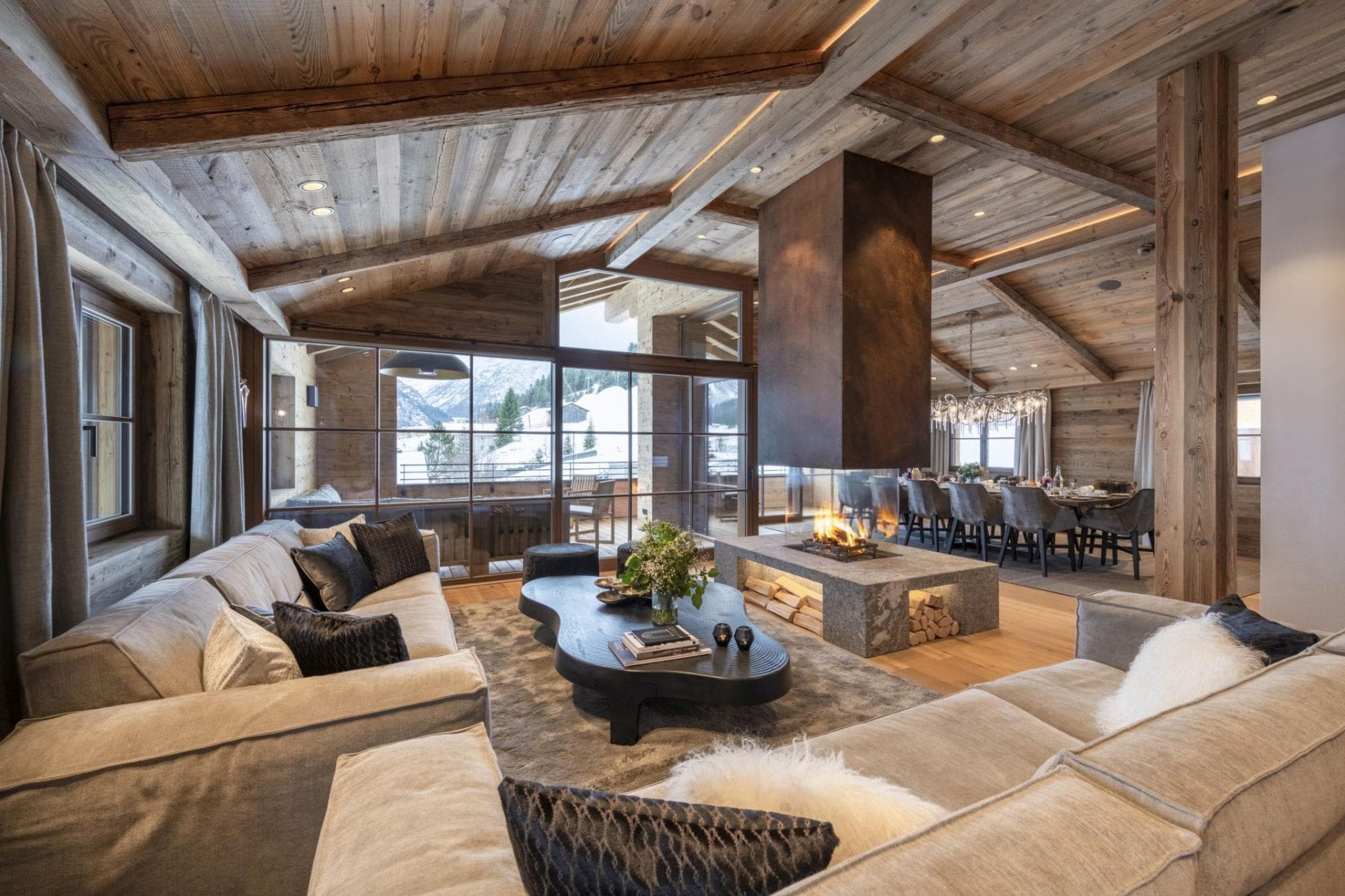 Living area with 360-degree glass fireplace and mountain views