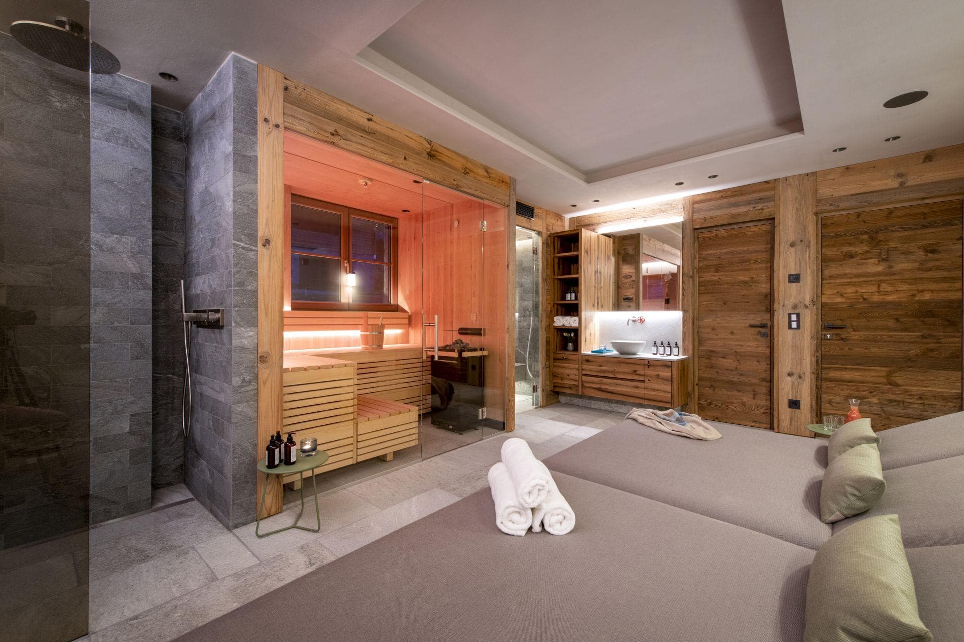 Private spa area with wood-clad sauna and stone rainfall shower