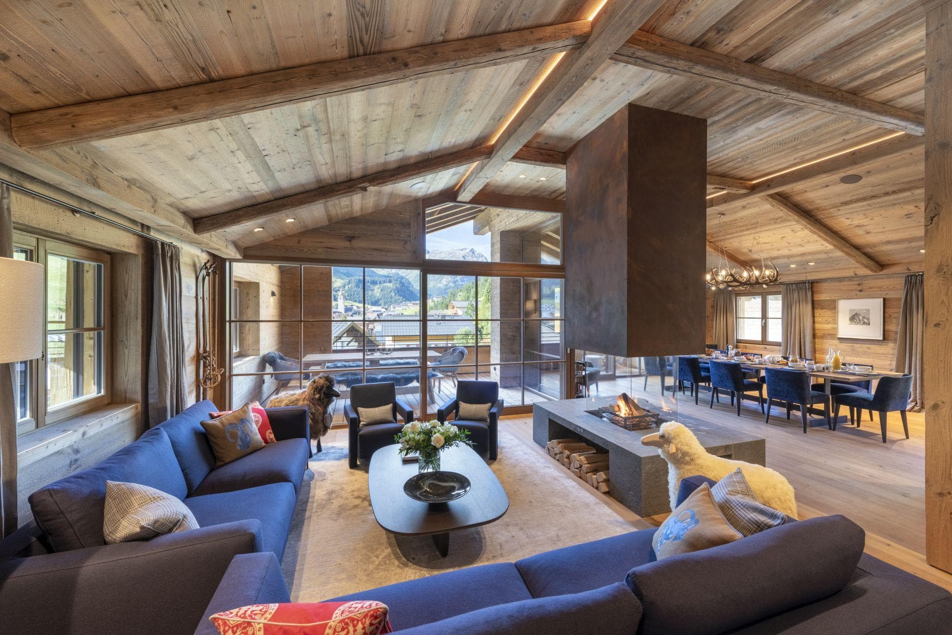 Open-plan living area with central glass fireplace and mountain views