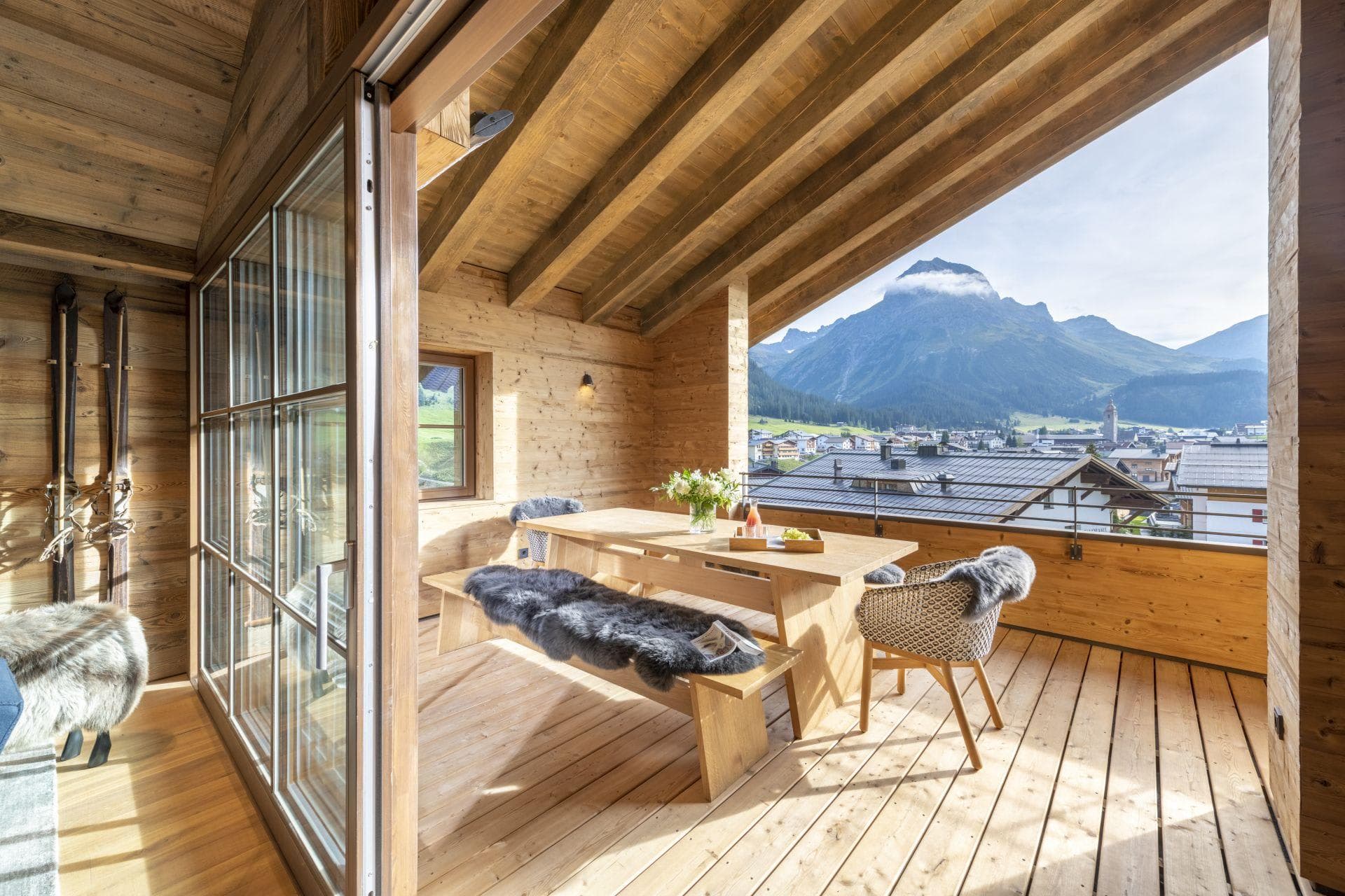 Covered balcony with dining table and mountain peak views