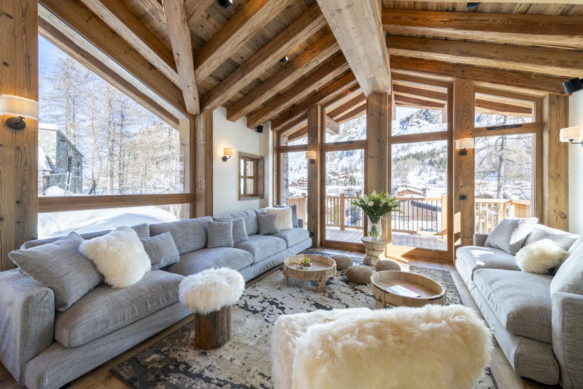 Living area with vaulted timber ceilings and floor-to-ceiling mountain views