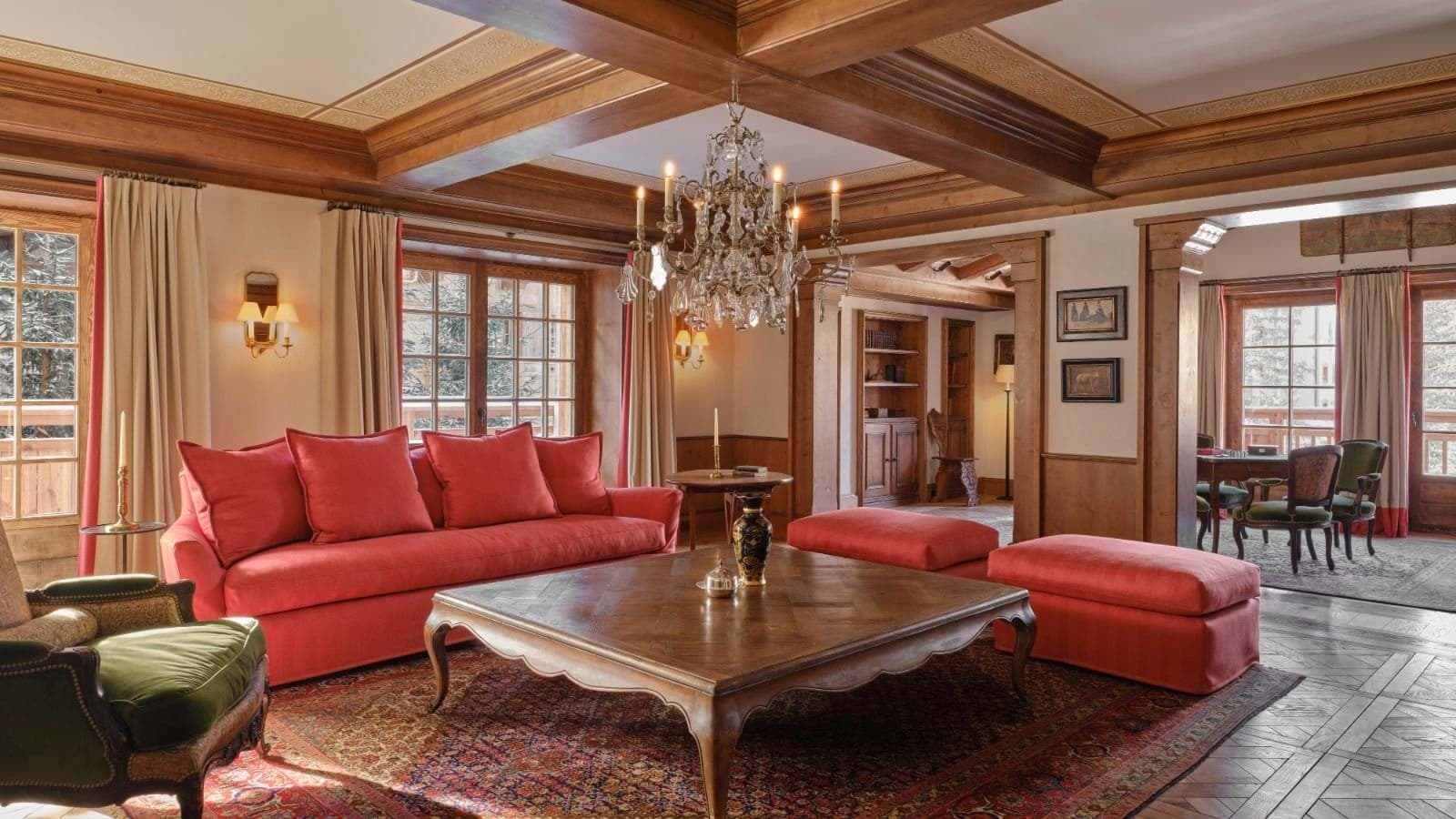 Living area with coffered ceilings, chandelier, and adjoining office space