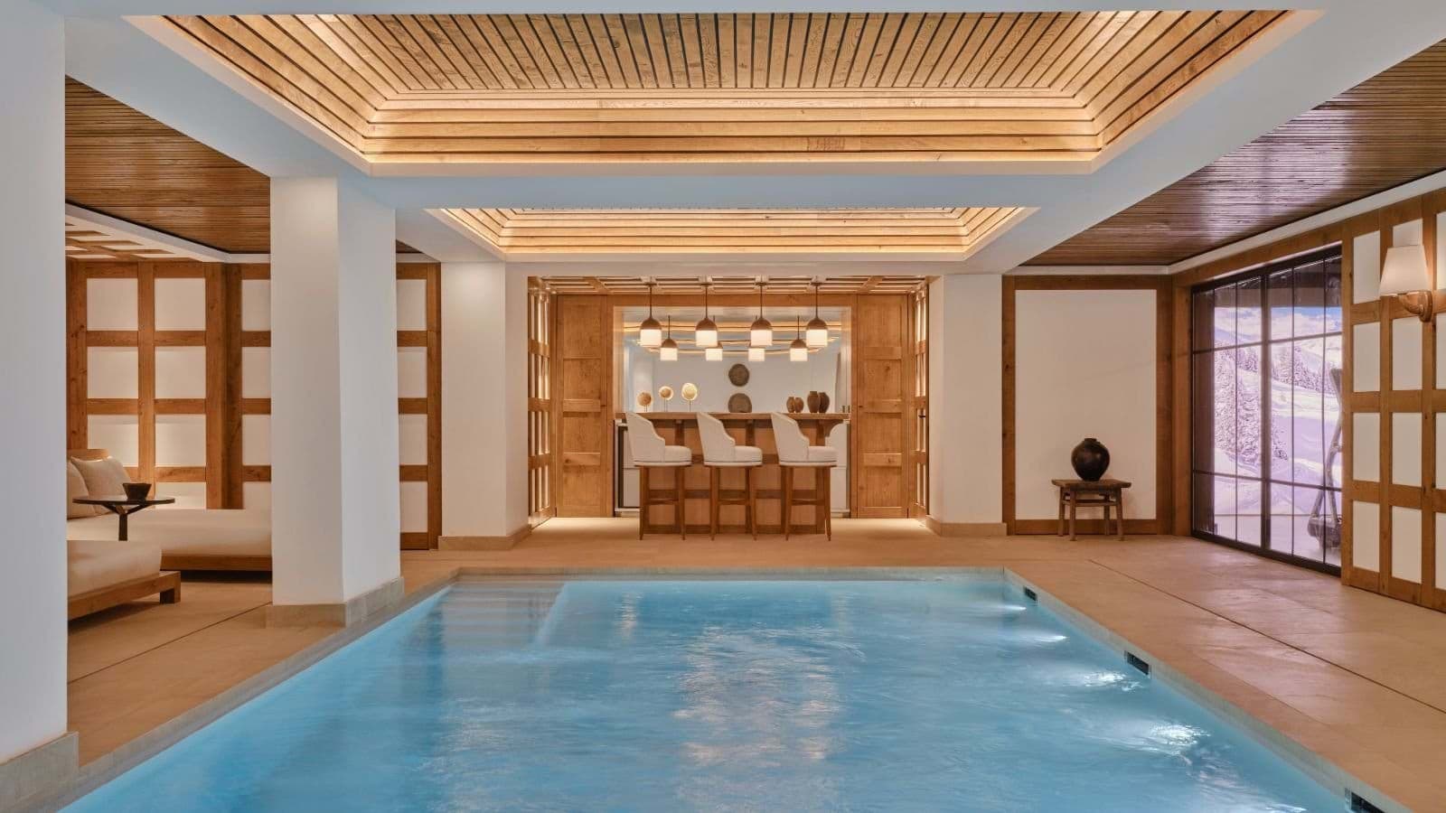 Indoor pool with three-stool wet bar and snowy mountain views