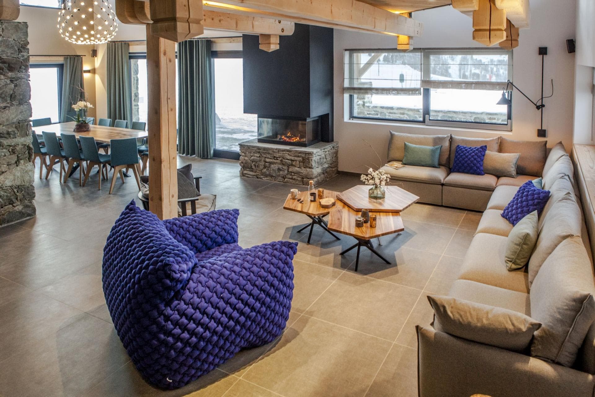 Open-plan living area with 3-sided fireplace and dining seating for 10