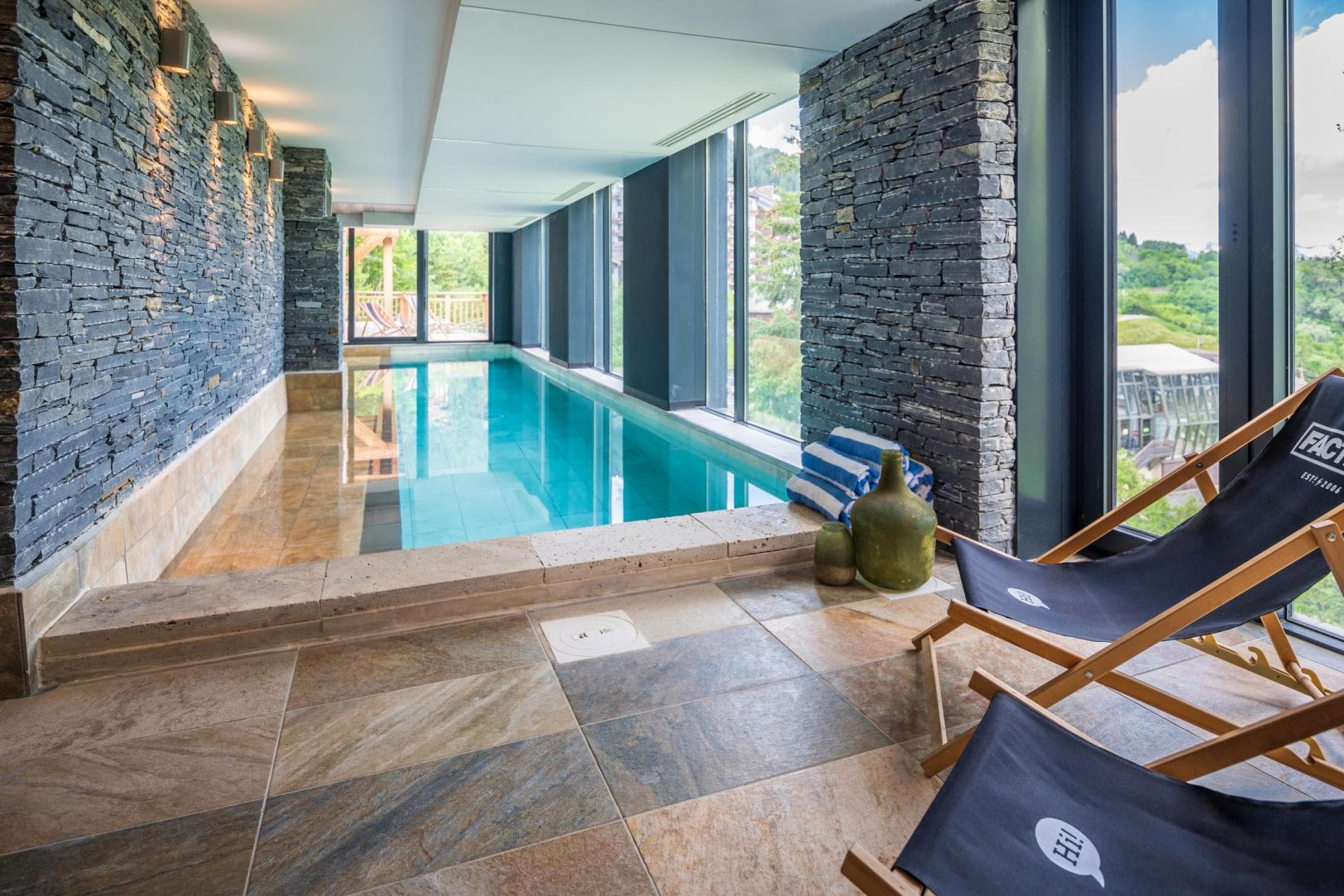 Indoor heated lap pool with floor-to-ceiling windows and mountain views