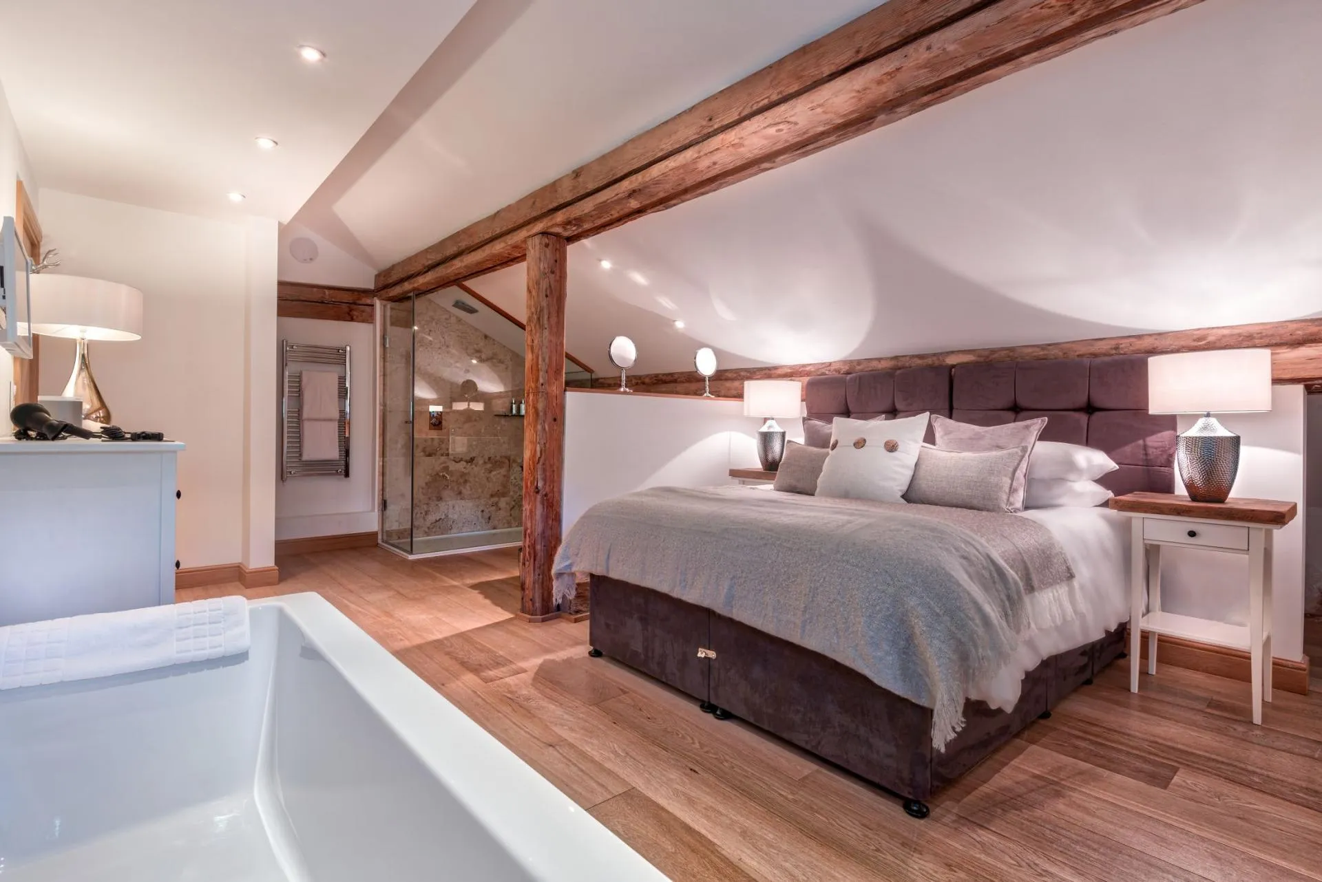 Loft bedroom with king bed and open-plan en-suite bathroom