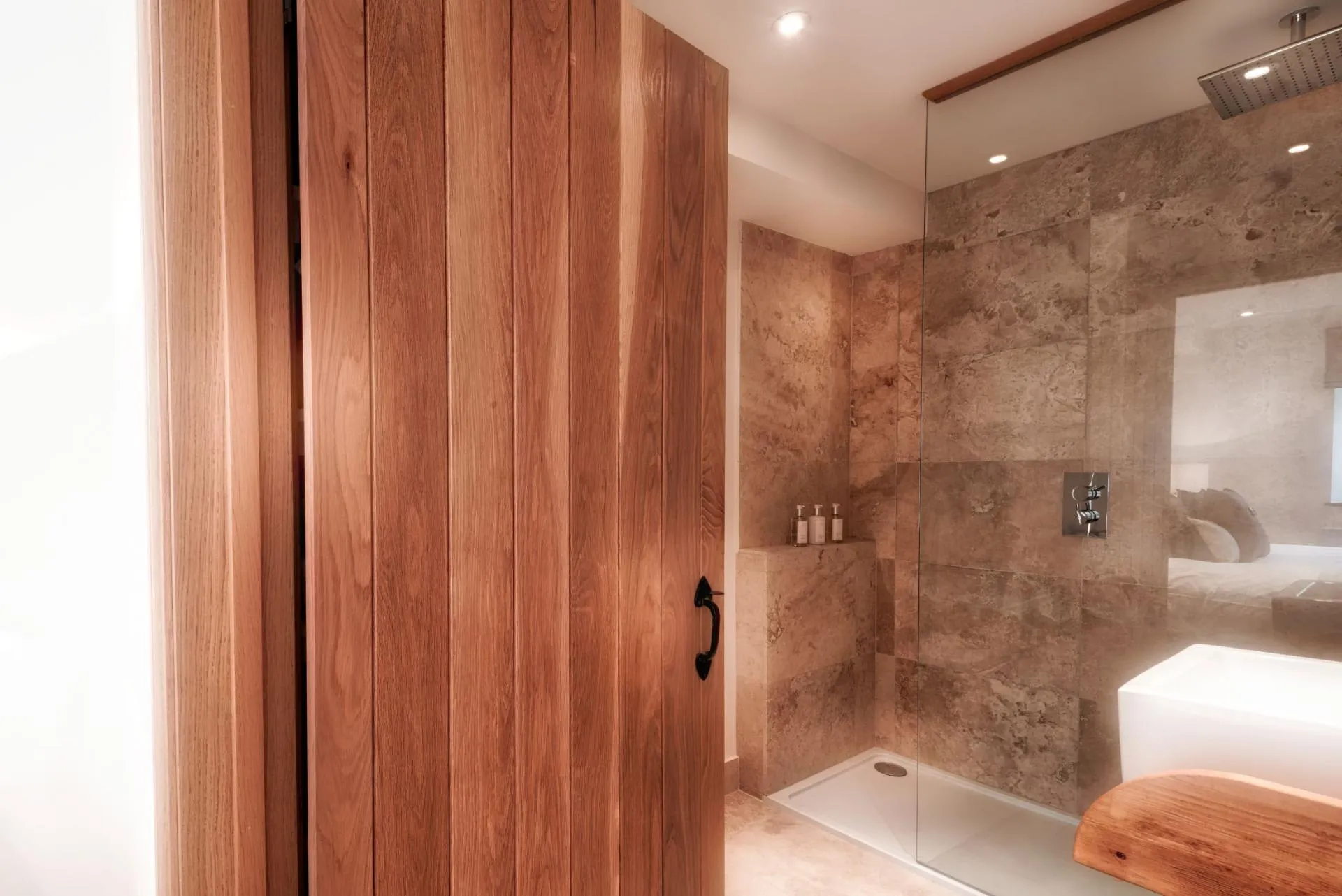 En suite bathroom with rainfall shower and sliding wood barn door