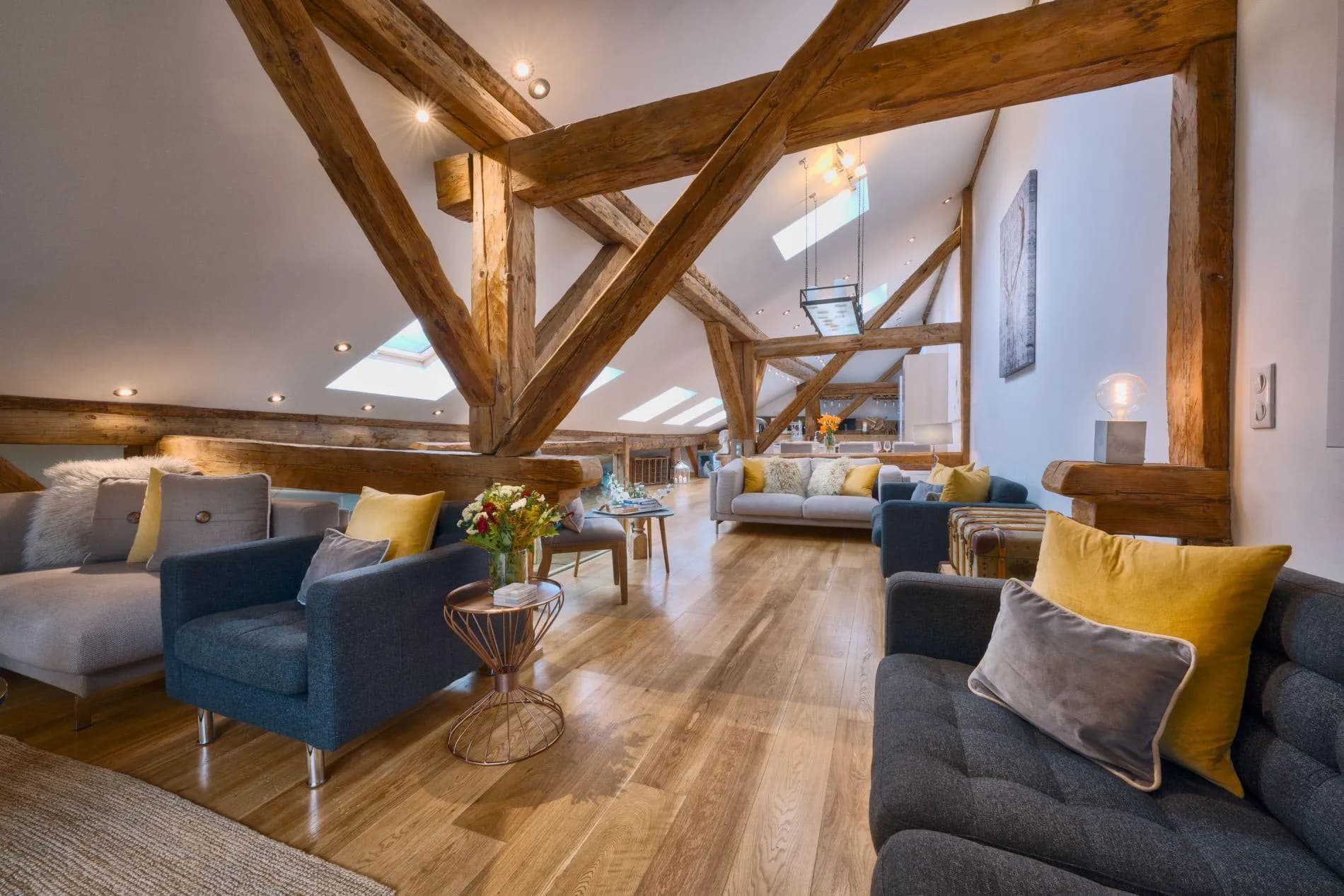 Loft living area with exposed timber beams and skylight windows