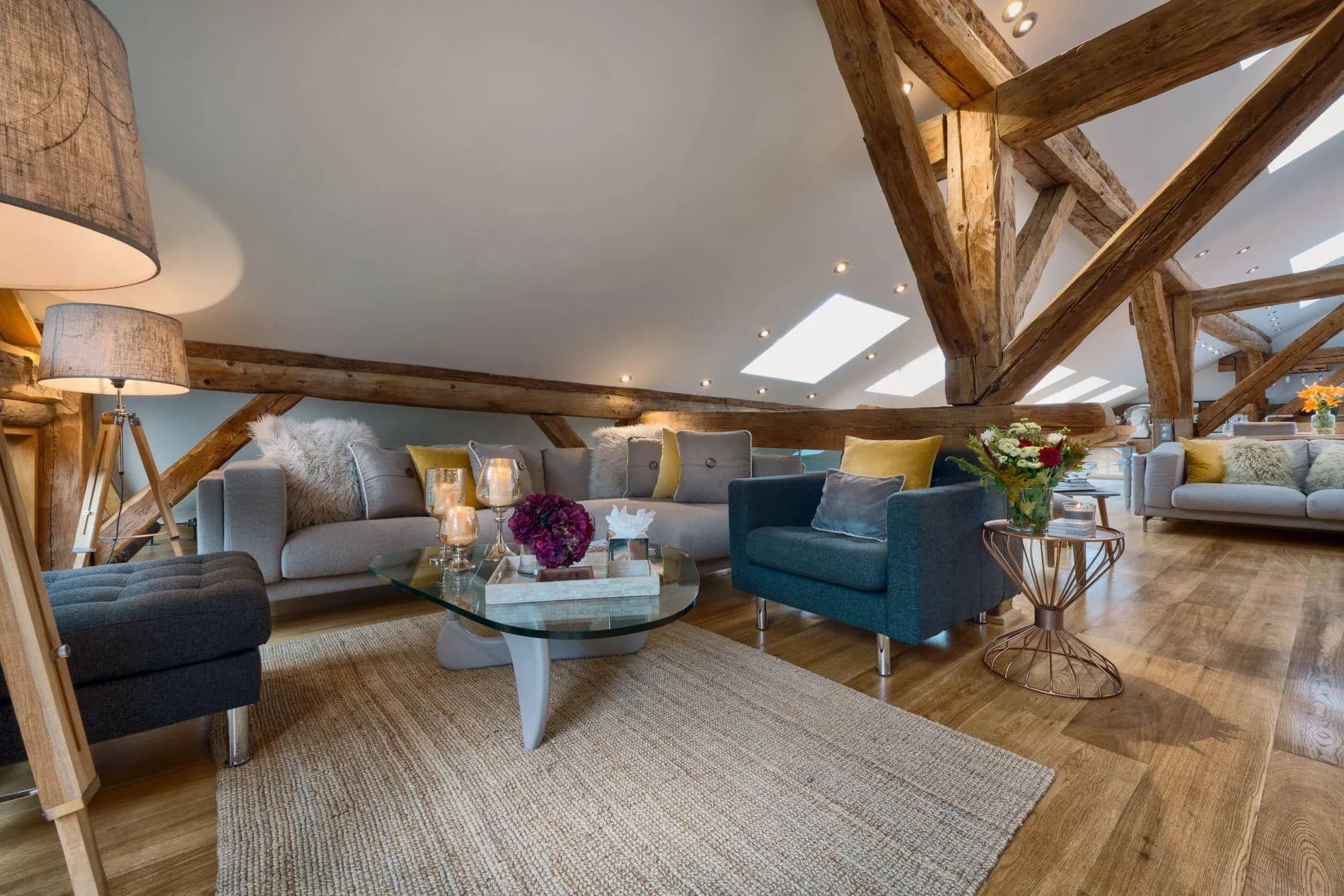 Loft living area with exposed timber beams and skylights