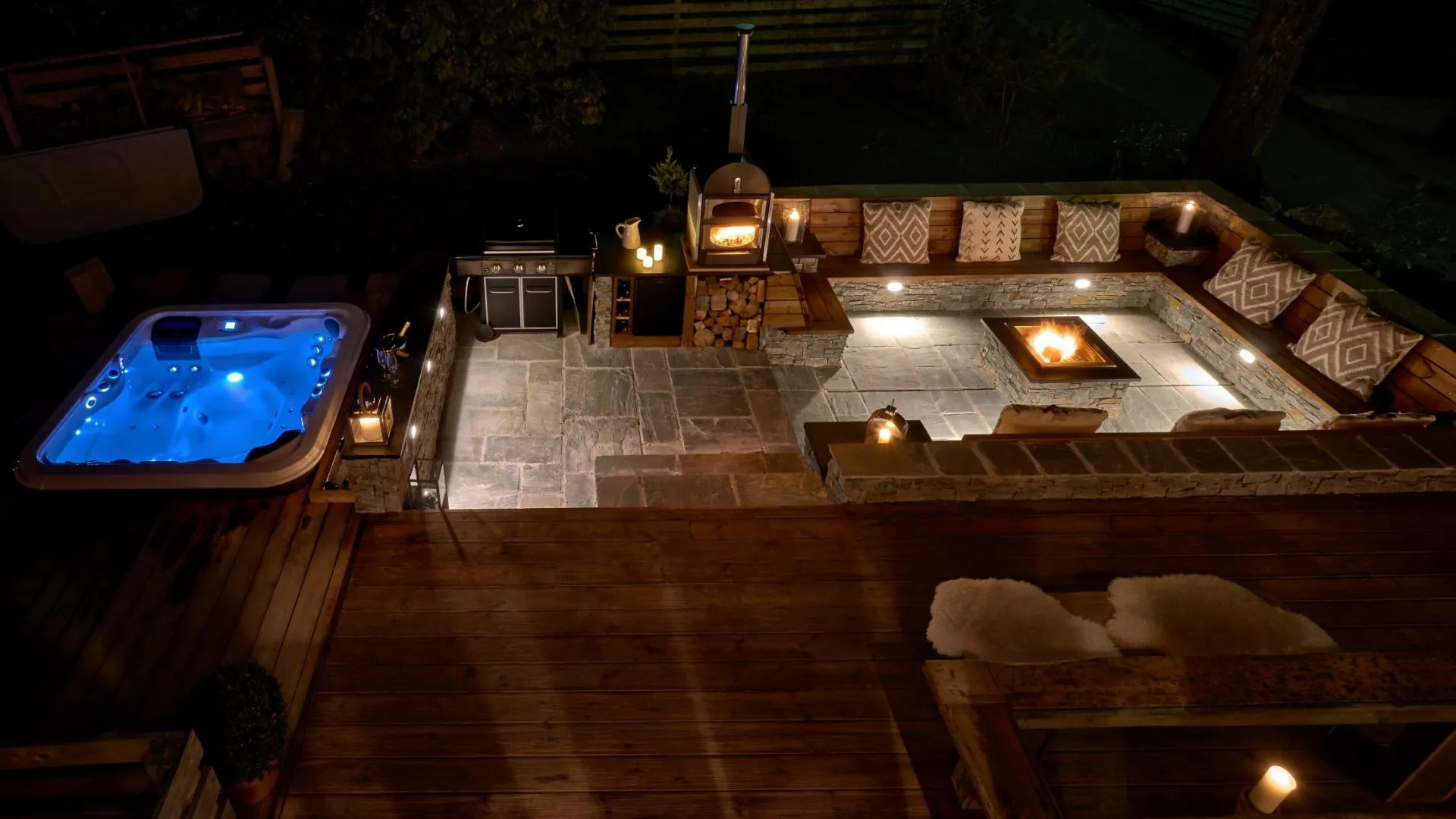 Patio with sunken fire pit, wood-fired pizza oven, and LED-lit hot tub
