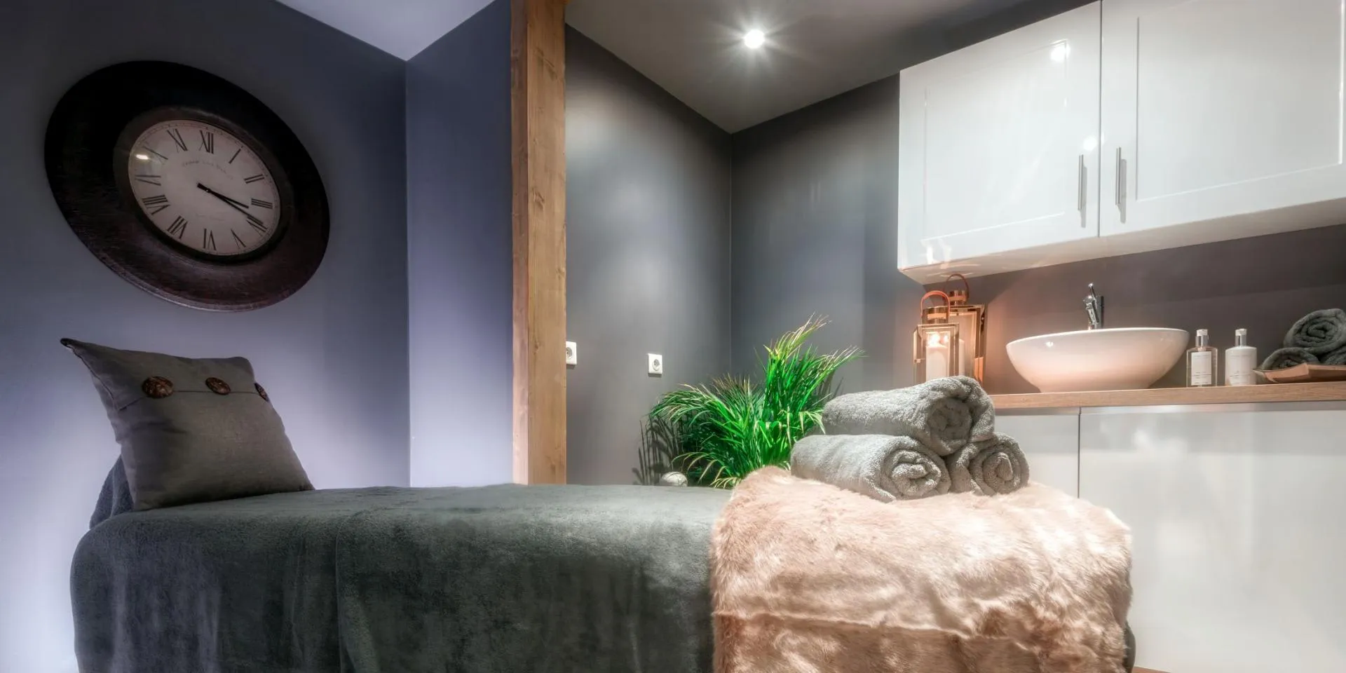 Private treatment room with massage table and vessel sink