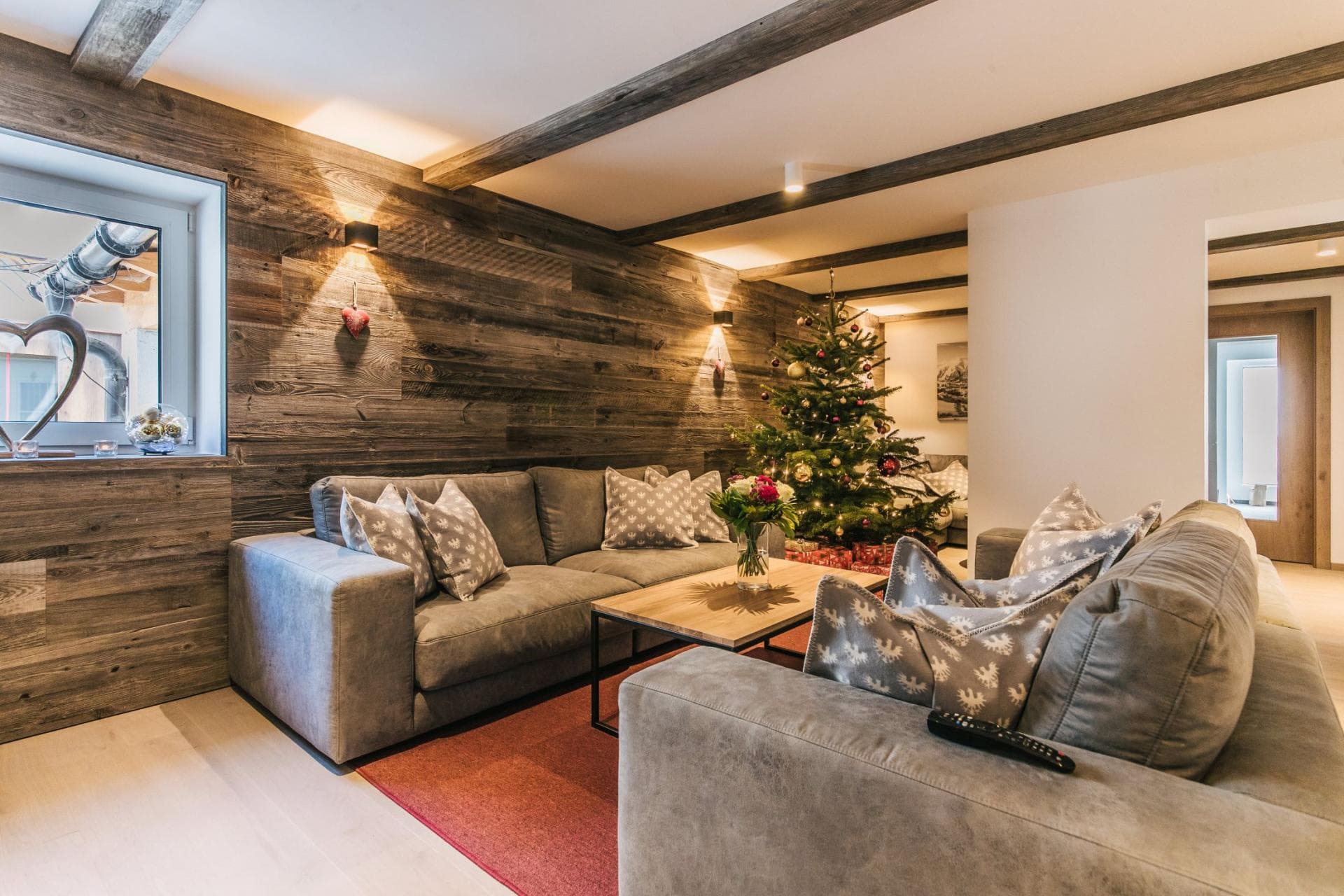 Living room with exposed beam ceiling, sectional seating for 6, decorated Christmas tree