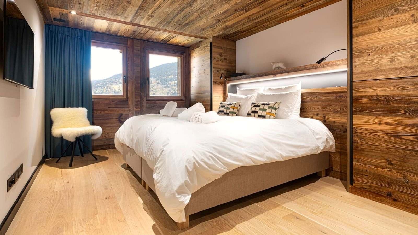 Wood-paneled bedroom with king bed and mountain valley views