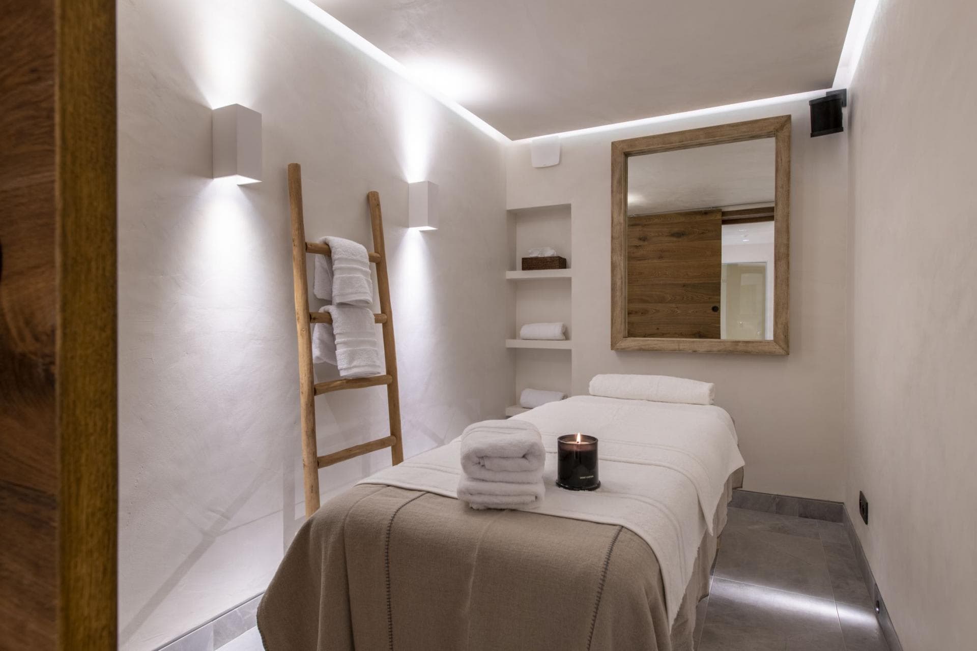 Private massage room featuring single treatment table and ambient lighting
