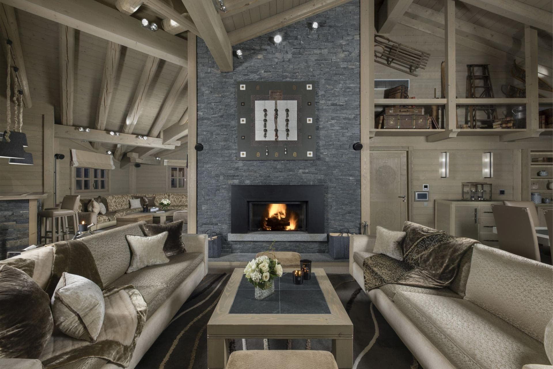 Living area with wood-burning stone fireplace and vaulted timber ceilings